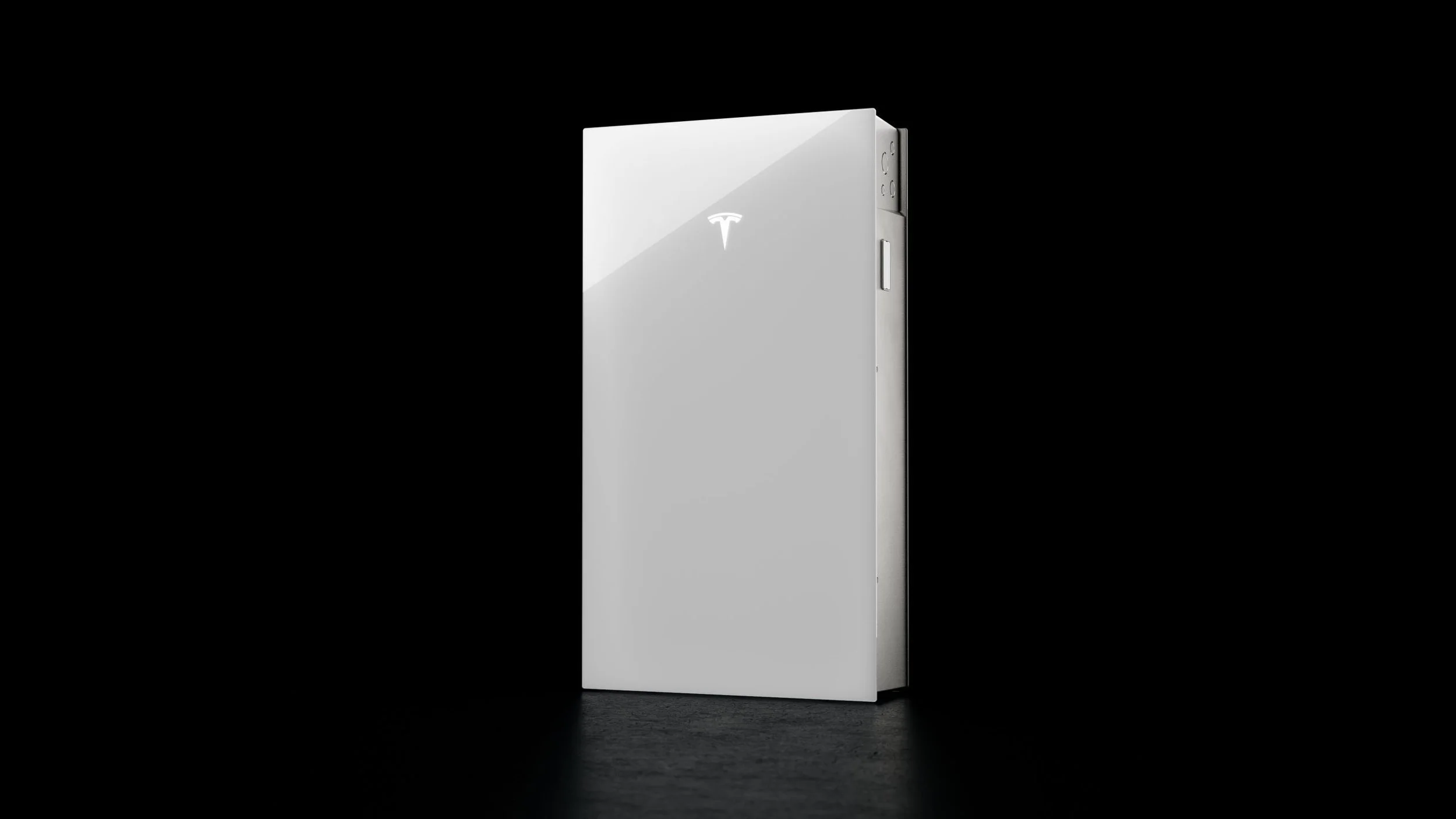 A sleek, modern, white Tesla Powerwall energy storage unit standing vertically on a dark background.