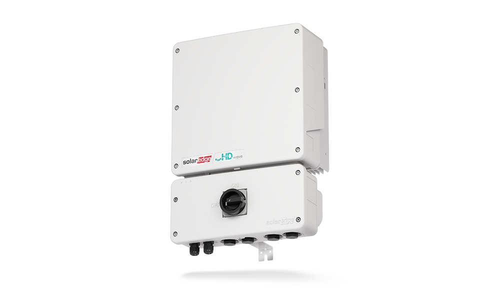 Two white solar power inverters mounted on a wall, connected with cables.