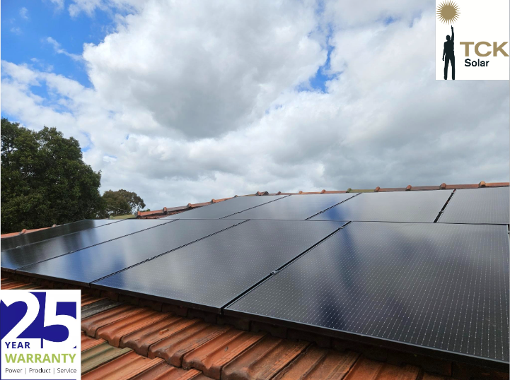 Solar panels installed on a rooftop under a cloudy sky, with a logo of TCK Solar in the top right corner and a 25-year warranty badge in the bottom left corner.