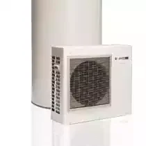 An outdoor air conditioning unit next to a tall white building or wall.