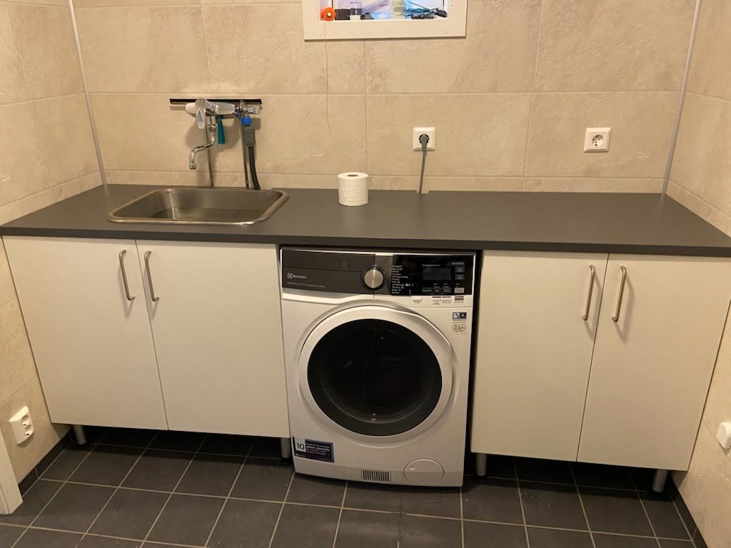 Vaskerom med benk og vaskemaskin.