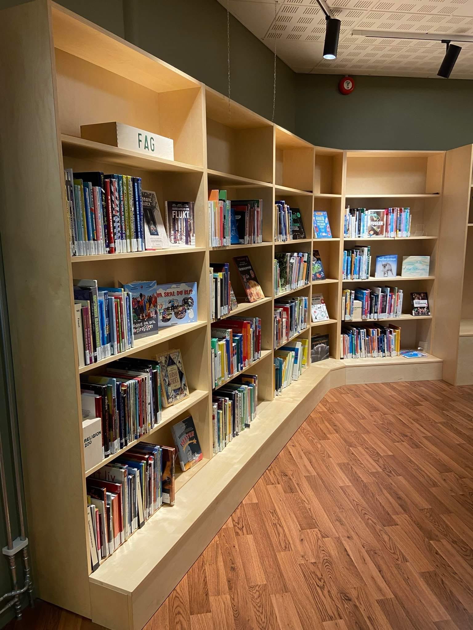 En lys hylle med bøker i en bokhylle, Lillehammer bibliotek. 
