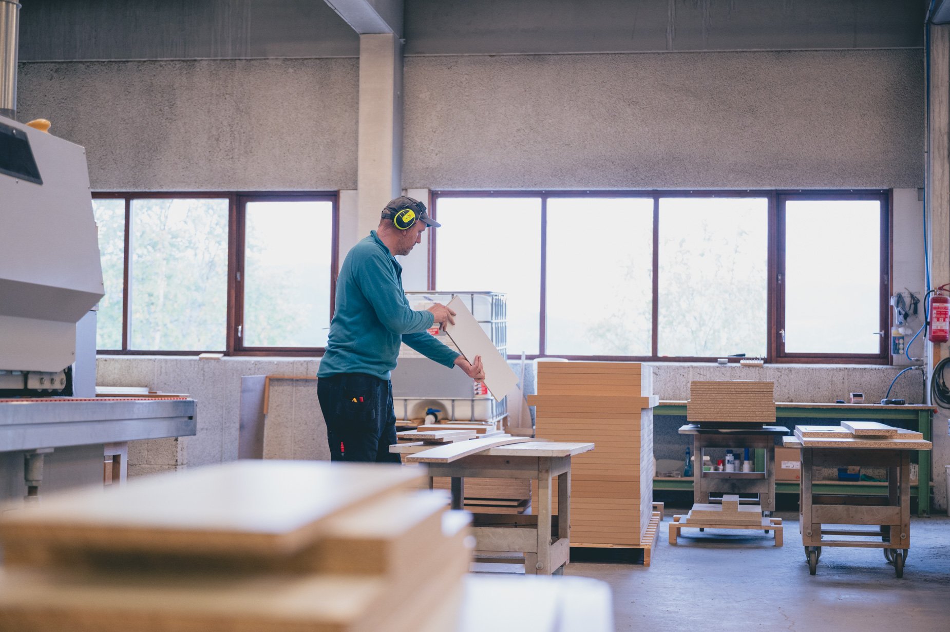 Produksjon hos Rundtom Møbelfabrikk, mann sjekker kvaliteten på ferdig emne til møbelet.