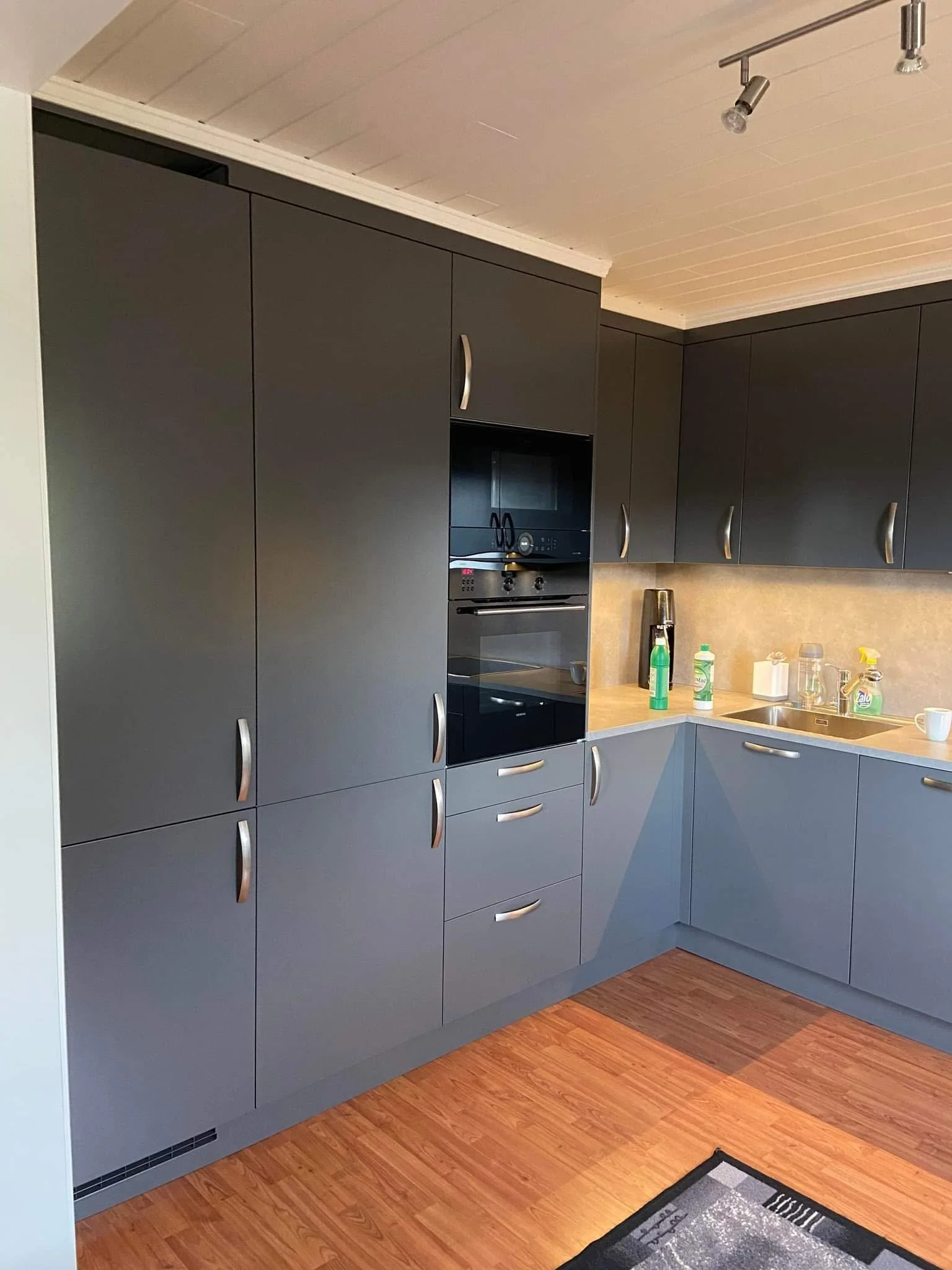 Moderne kjøkken med mørke skap, privat bolig.