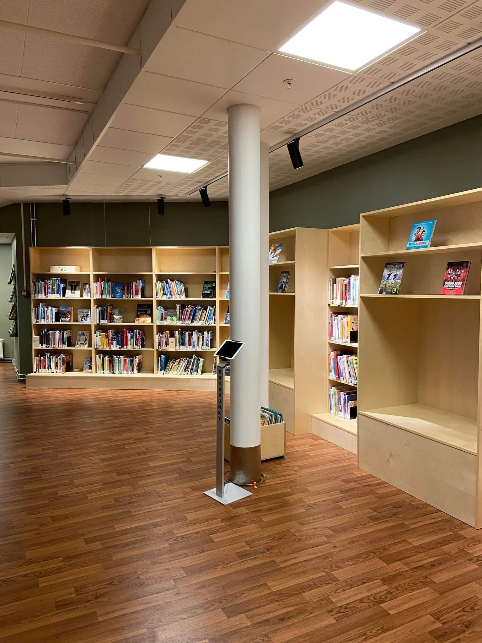 En lys hylle med bøker i en bokhylle, Lillehammer bibliotek. 