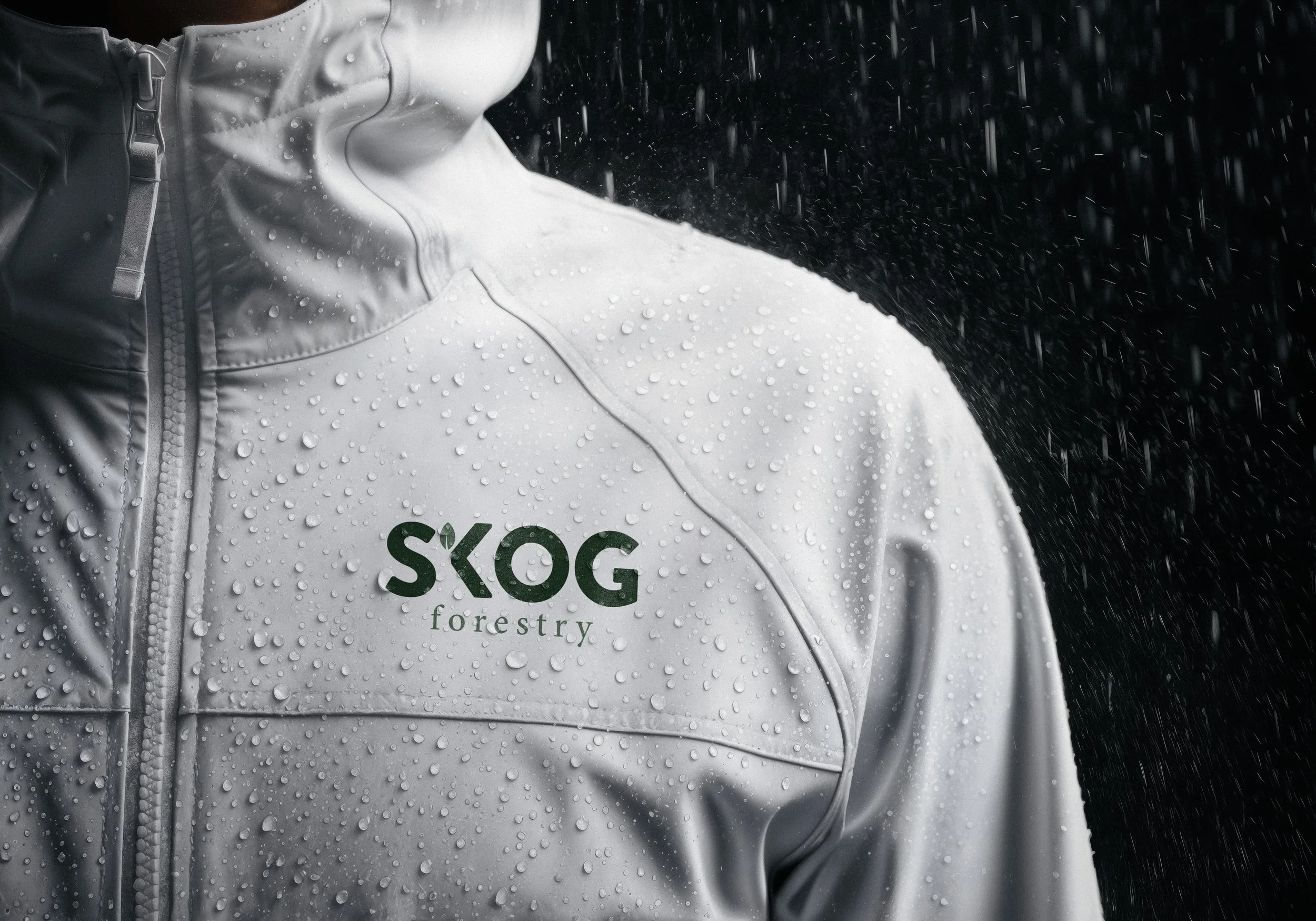 Close-up of a rain-covered forestry worker wearing a jacket labeled “SKØG forestry”