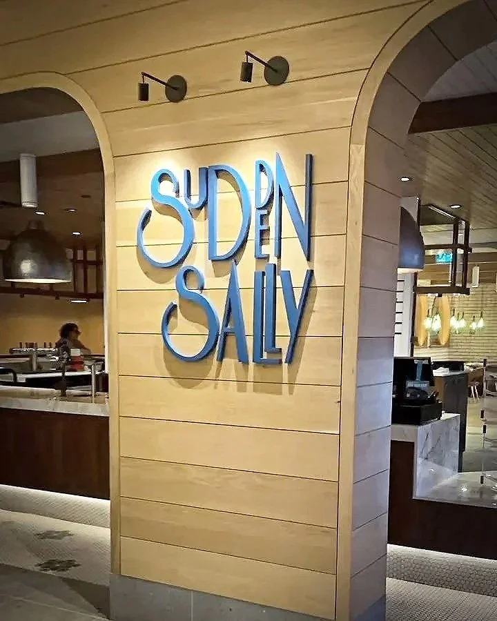 Interior sign reading “SUDDEN SALE” at a restaurant or retail store entrance.
