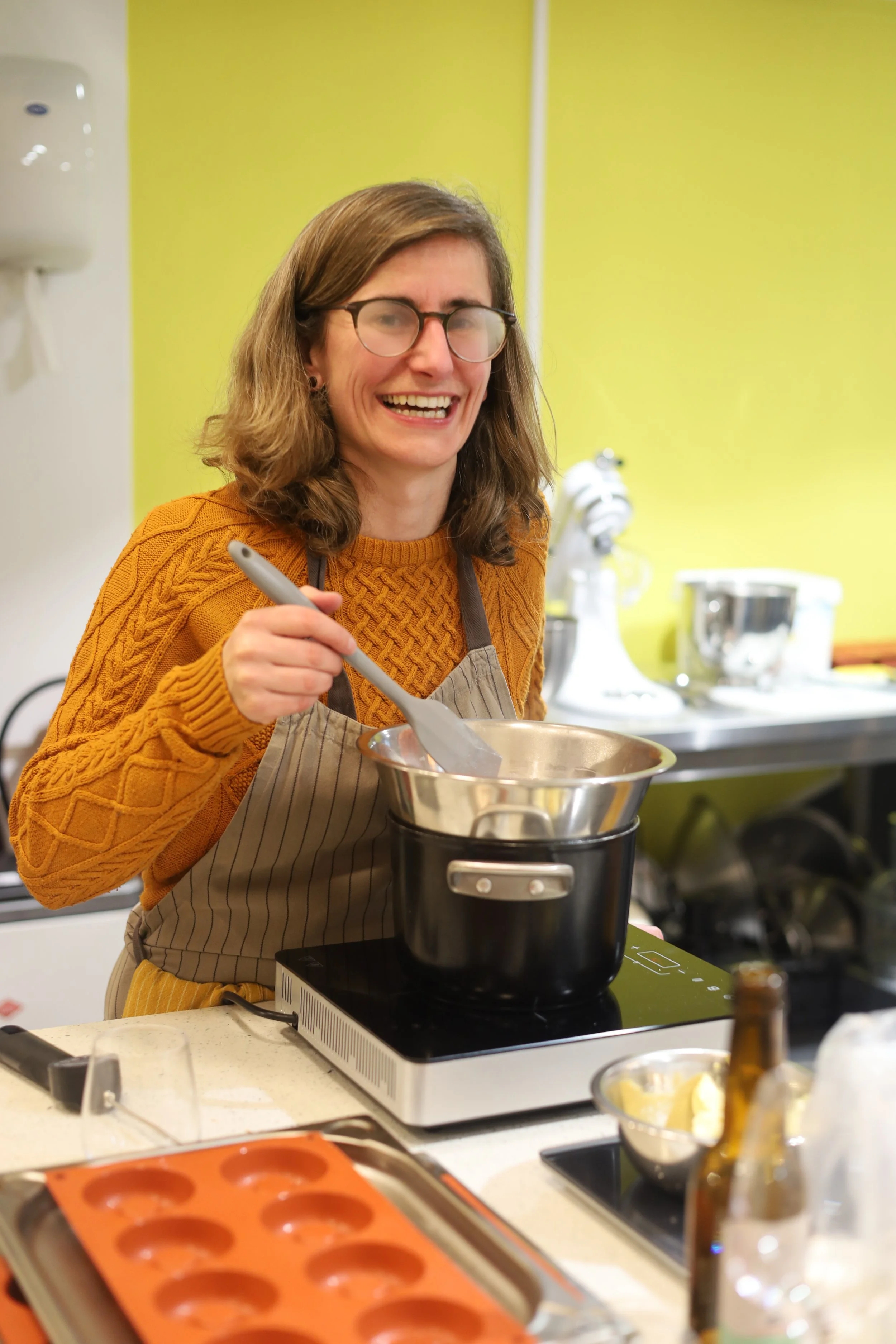 Vrouw met bril die in een keuken kookt, kookt in een pan op een inductieplaat.