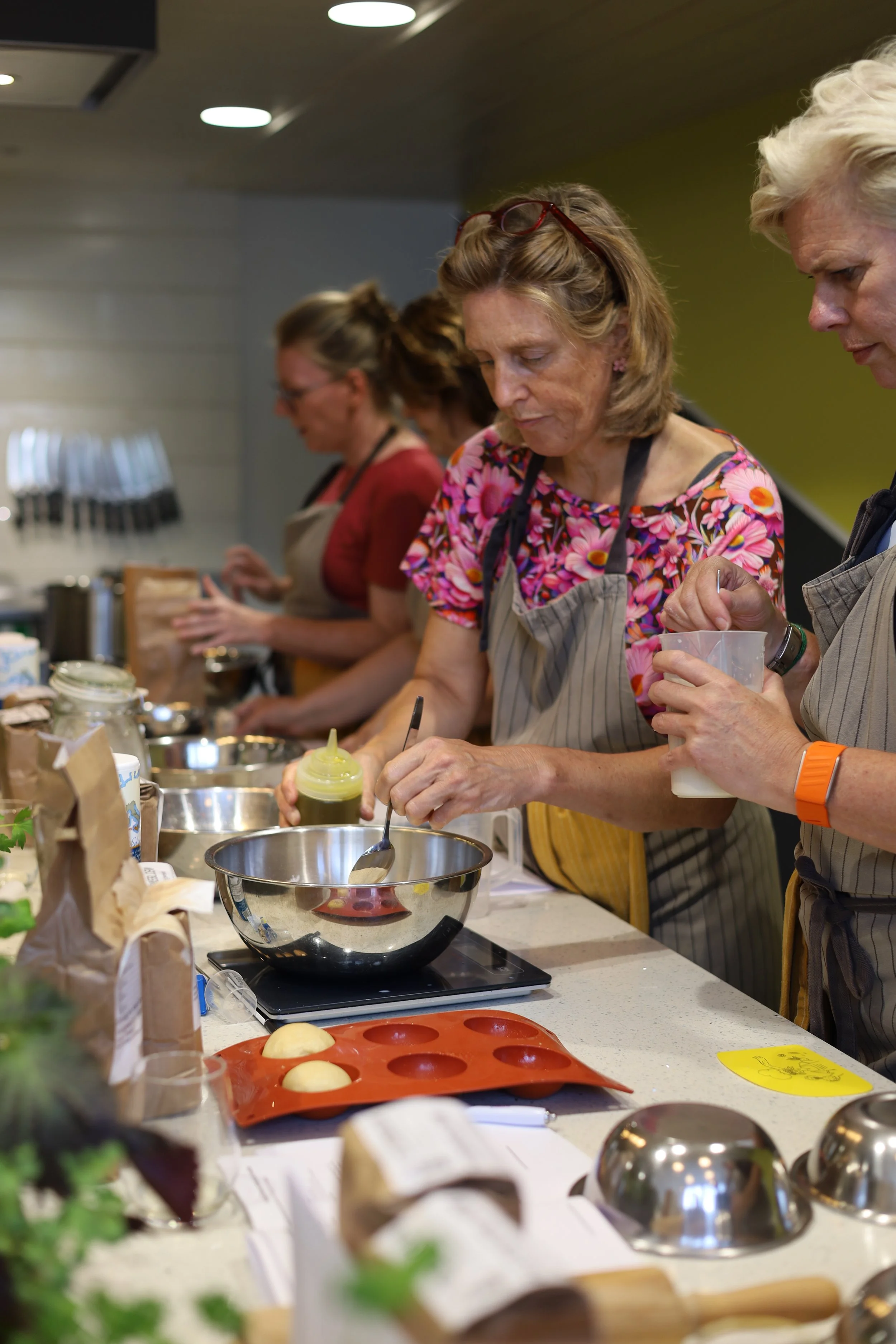 Mensen bereiden in een keuken, met bakbenodigdheden en ingrediënten op het aanrecht.