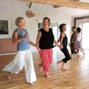 Groupe de femmes qui dansent dans une pièce lumineuse.