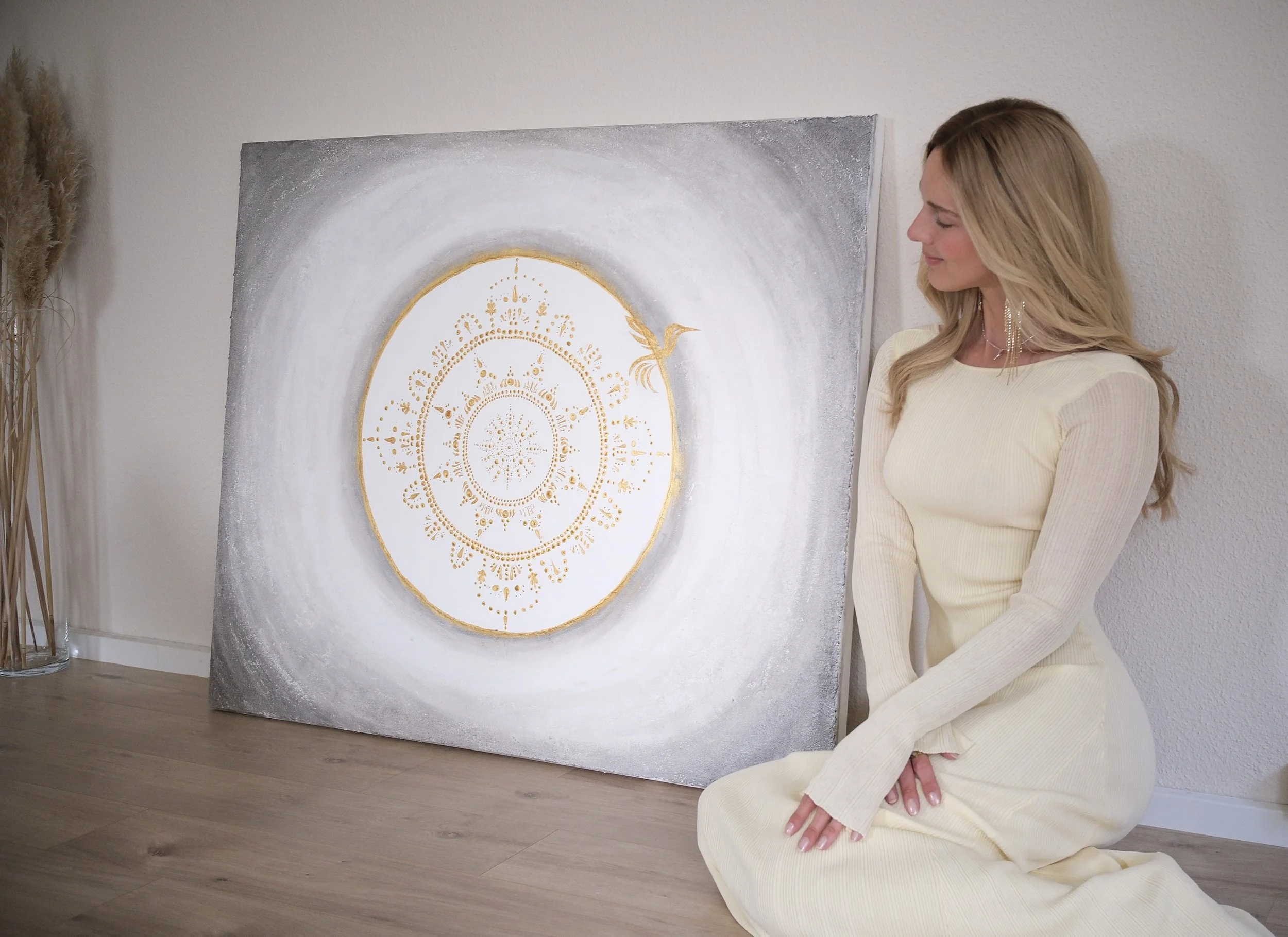 Larissa Maddy beside one of her original abstract paintings for Shala Vida