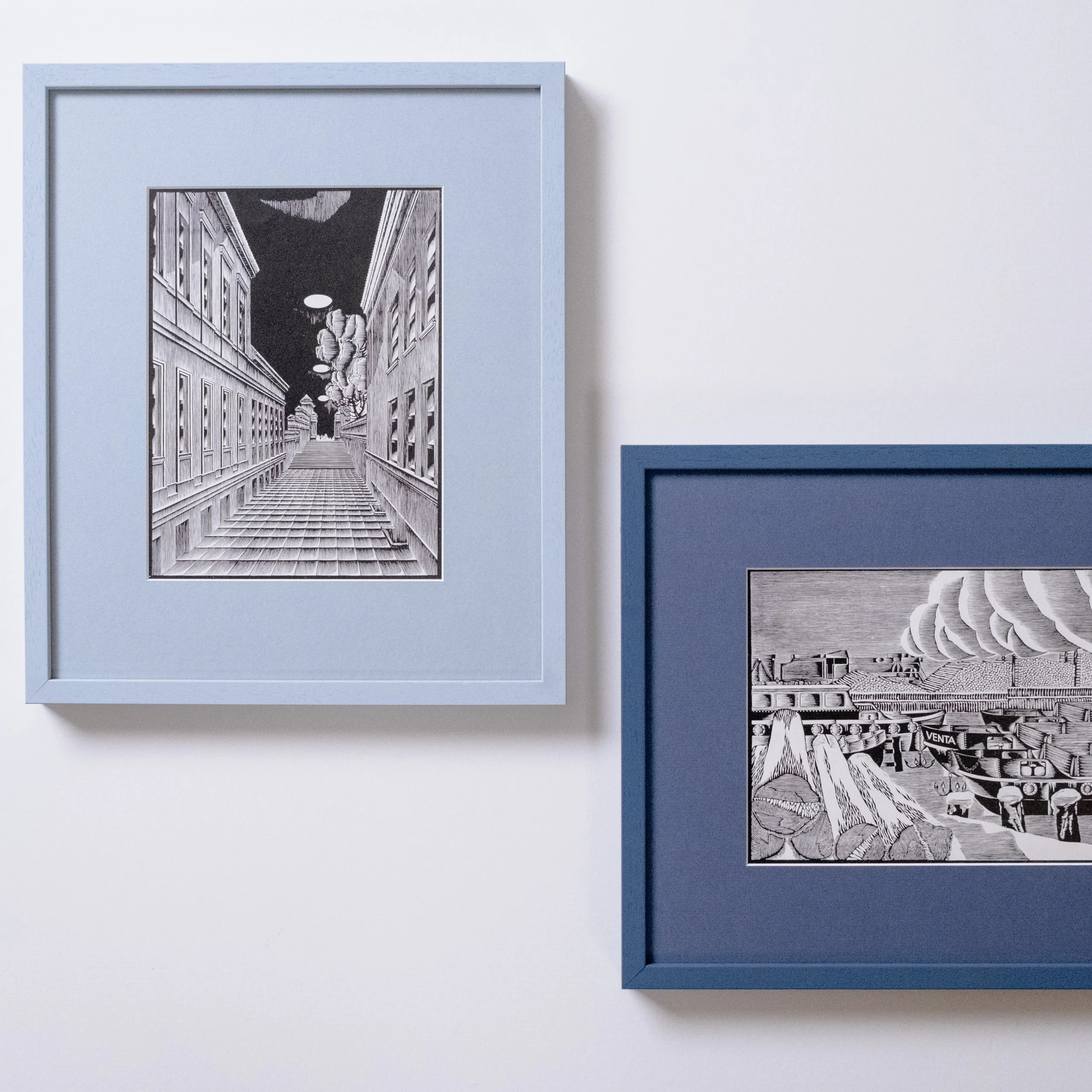 A pair of monochrome linocut illustrations in portrait and in landscape orientation, in complementary blue moulding profiles and colour-matched mountboard
