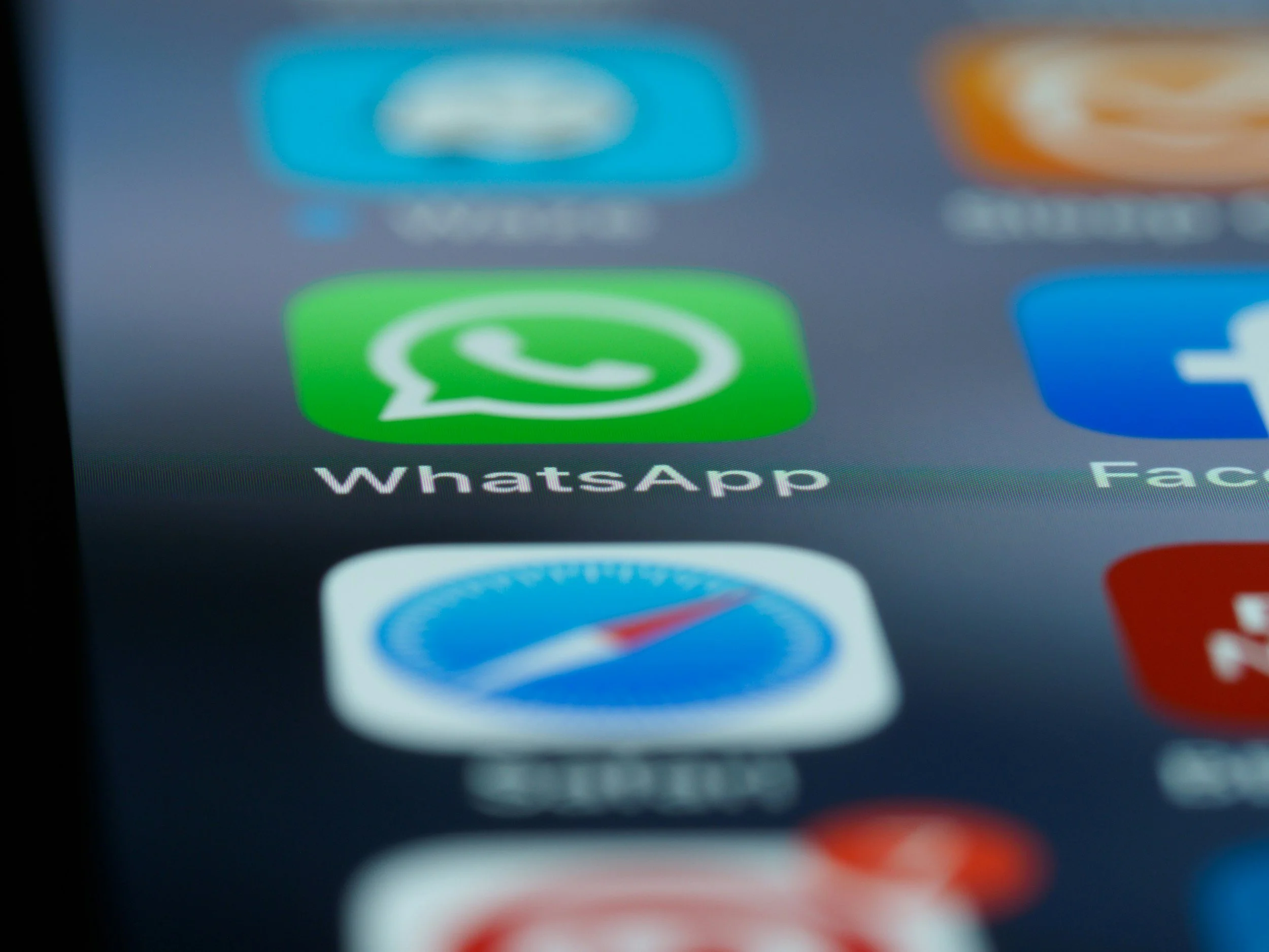 Tela de smartphone com o ícone do WhatsApp na tela inicial, visível em destaque na imagem.