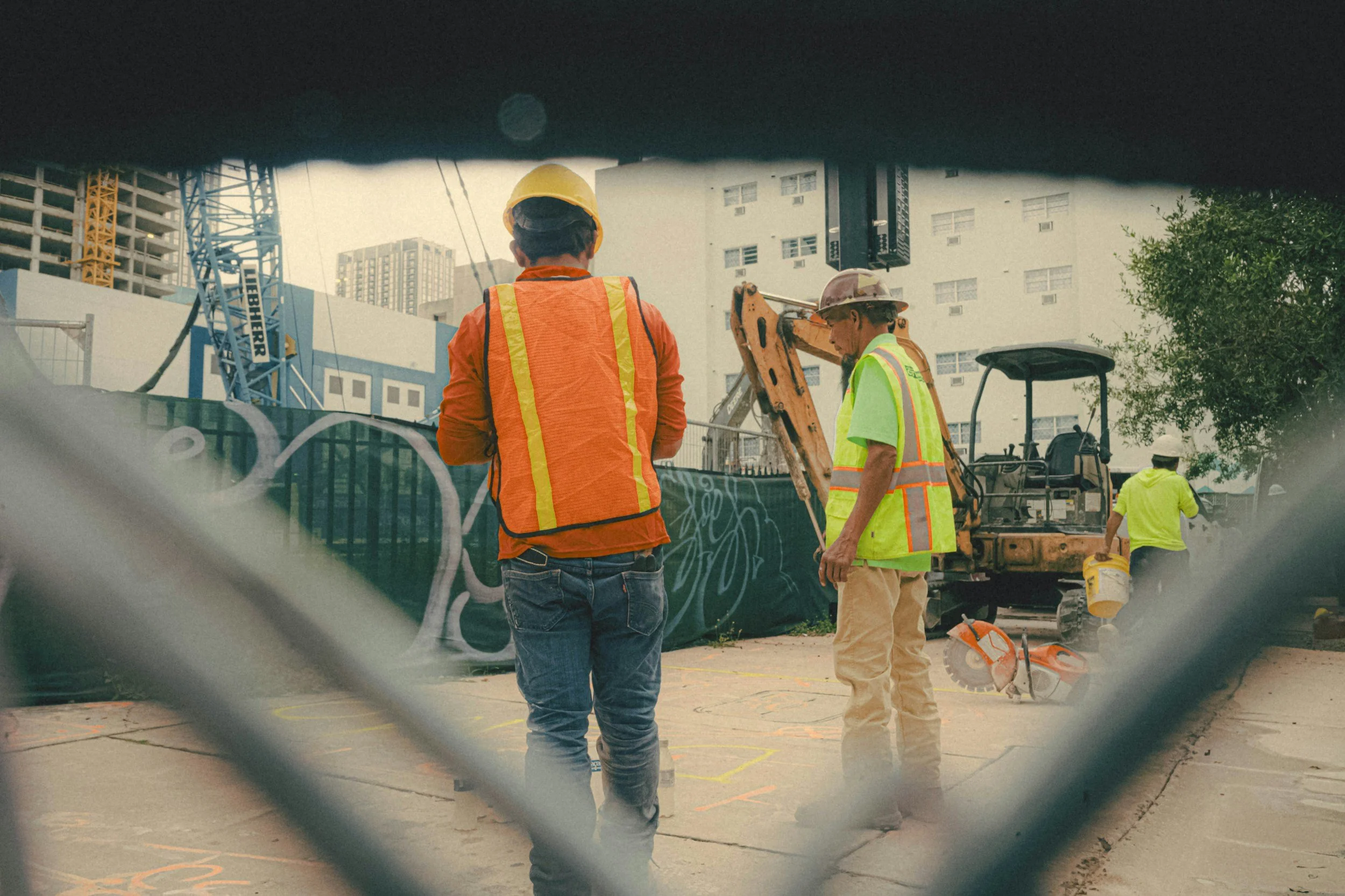 Trabalhadores da construção civil usando equipamentos de segurança em um canteiro de obras na cidade.