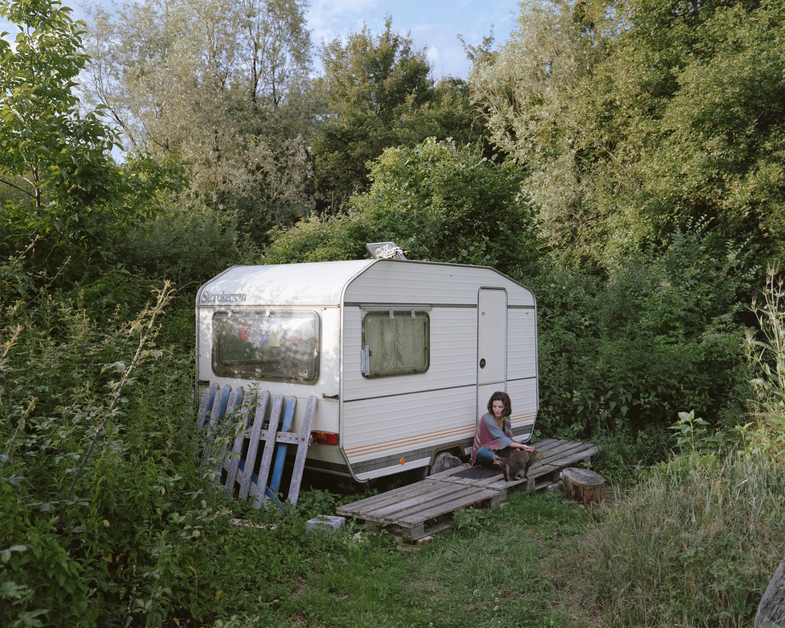Camille devant la caravane qu'elle partage avec Guillaume (et le chat du voisin).