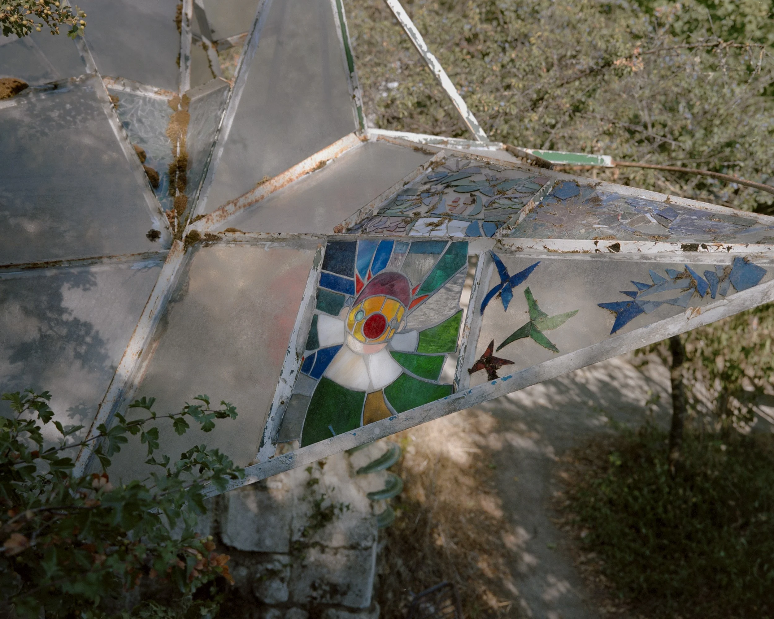 Un vitrail représentant un clown. Le passé d'artistes des deux fondateurs, Pako et Zaz, se ressent fortement dans Troglobal. Sculputres, installations, vitraux, sont visibles un peu partout sur le terrain, chacun étant invité à y créer quelque chose.