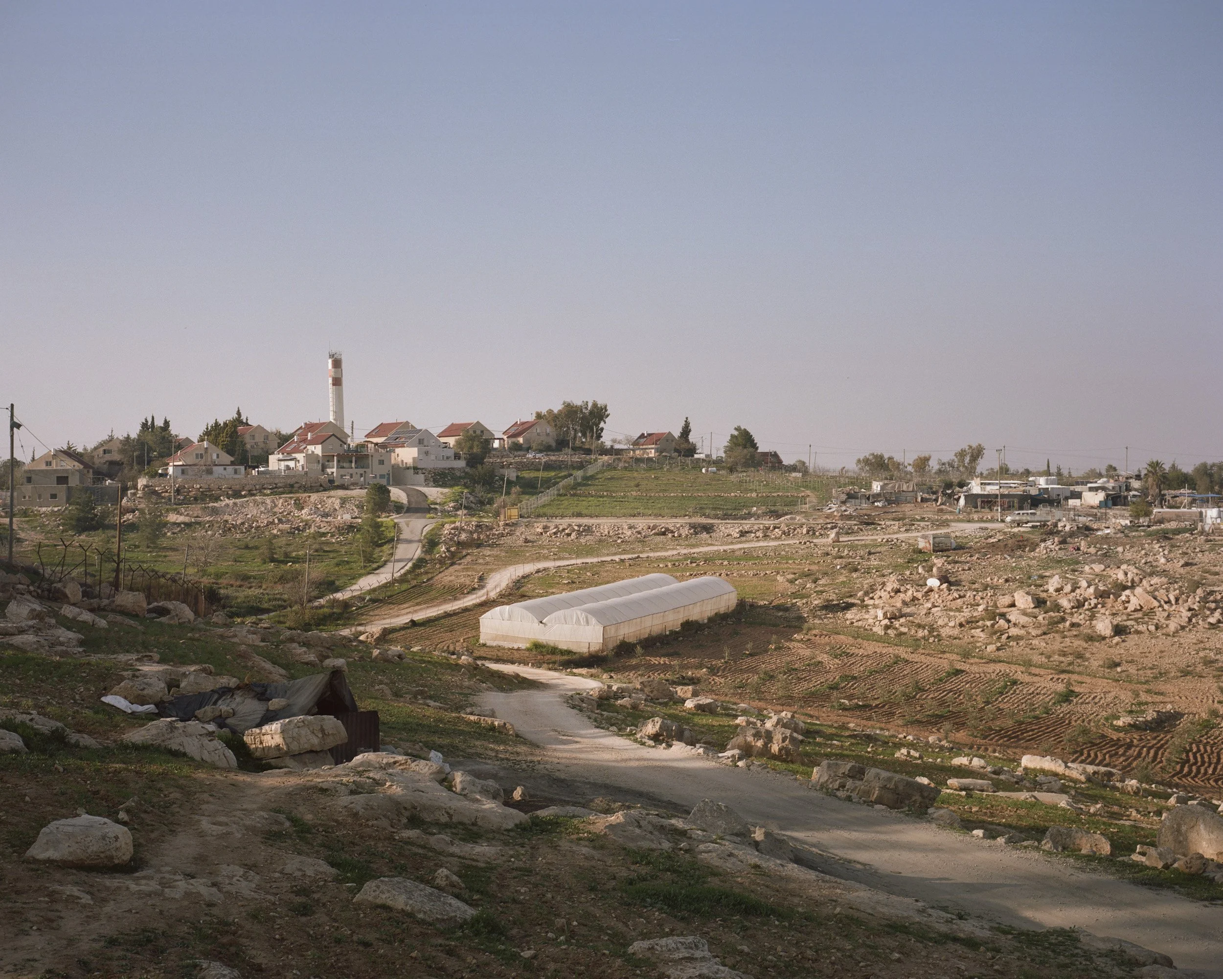 Umm Al-Khair (right) and the settlement of Carmel. The Bedouin village, built mainly of iron houses, contrasts with the equipped country houses of the colony. West Bank.