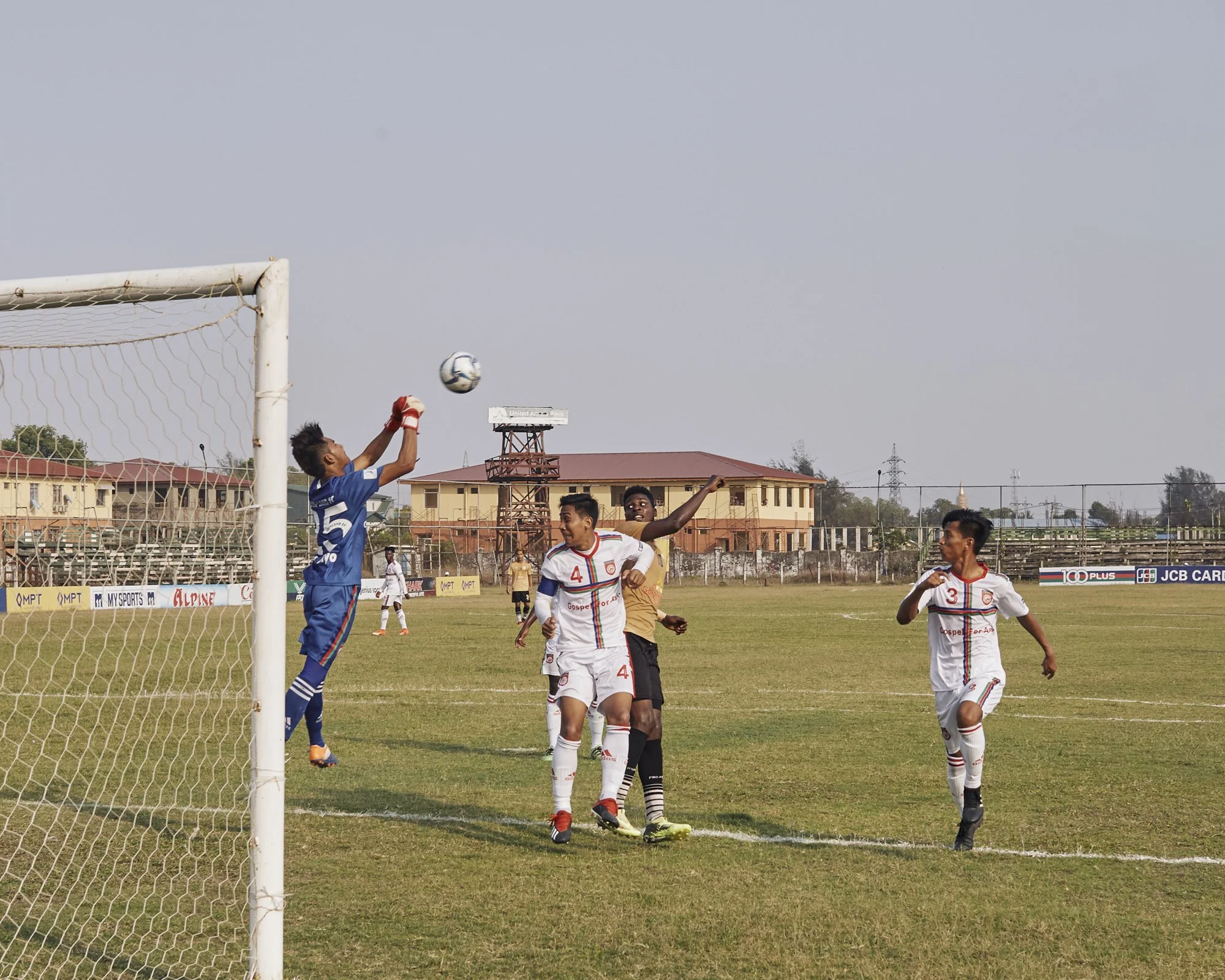 Samuel battles with players from the opposing team during the Rakhine United Football Club vs Chinland game, July 4 2019 Sittwe, Rakhine, Myanmar. © Lucien Lung / Riva