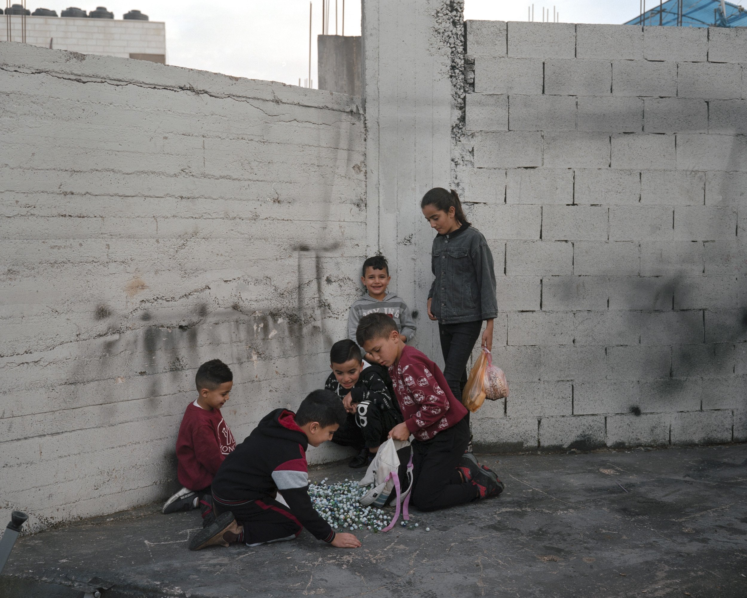Children from Aida refugee camp playing marbles. Bethlehem, November 2021.