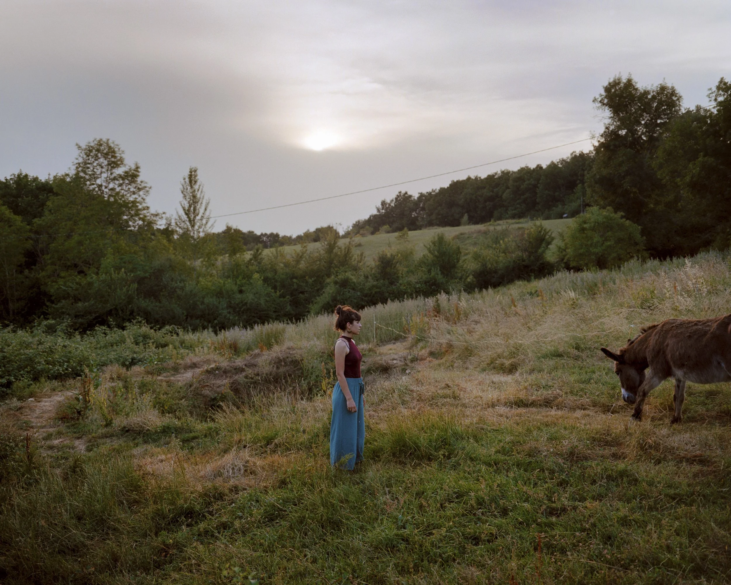 Camille, naturopathe et habitante de Sainte-Camelle, s'occupe de Bandit, un des deux ânes sur le terrain du village. Les résidents ont calculé quil faut 4000 h de travail par an pour que le lieu fonctionne, ce qui,  réparti parmi les habitants, équiv