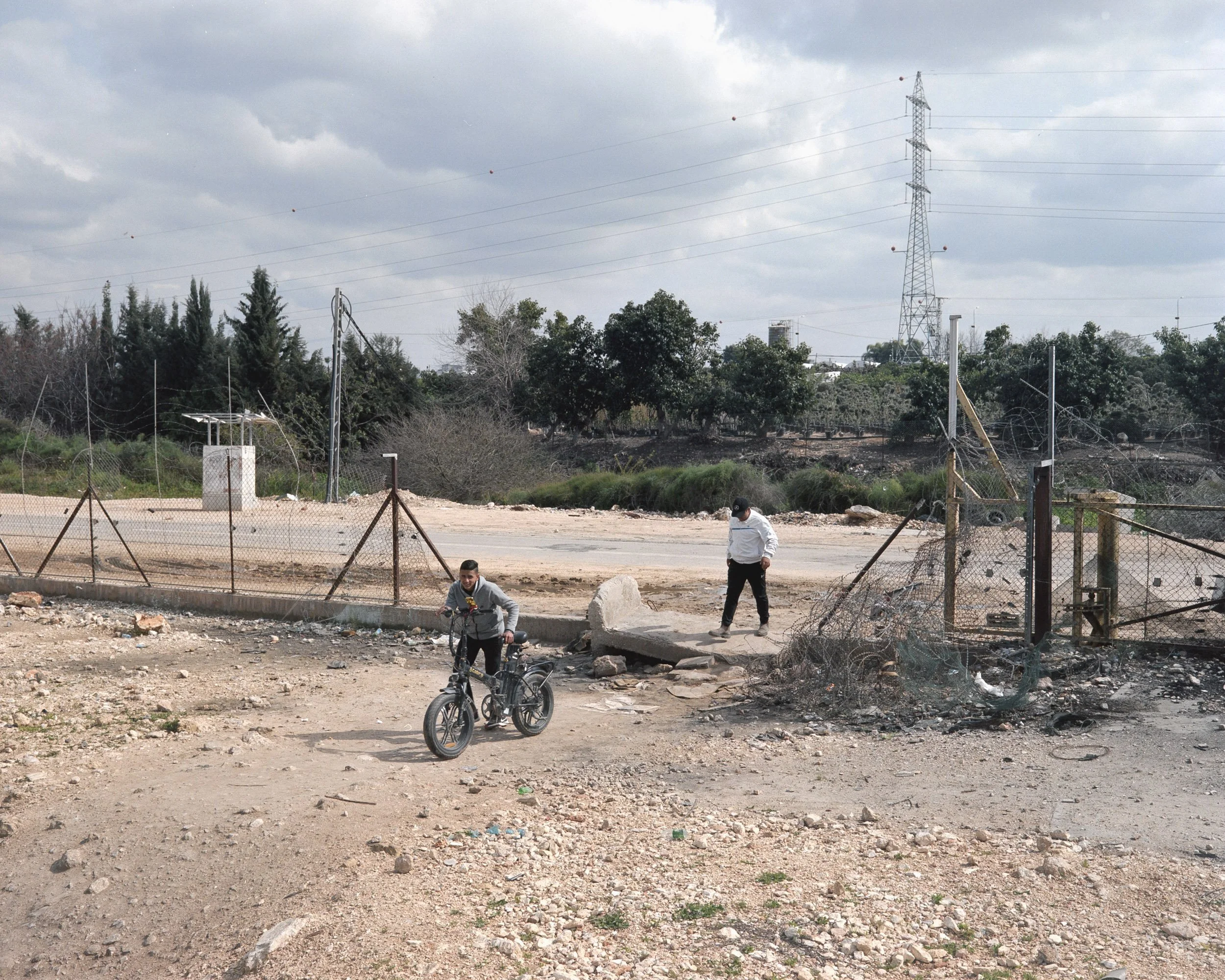 Palestinian workers pass through a gap in the barbed wire section of the separation wall in Qalqiliya, West Bank, used to go to work in Israel.