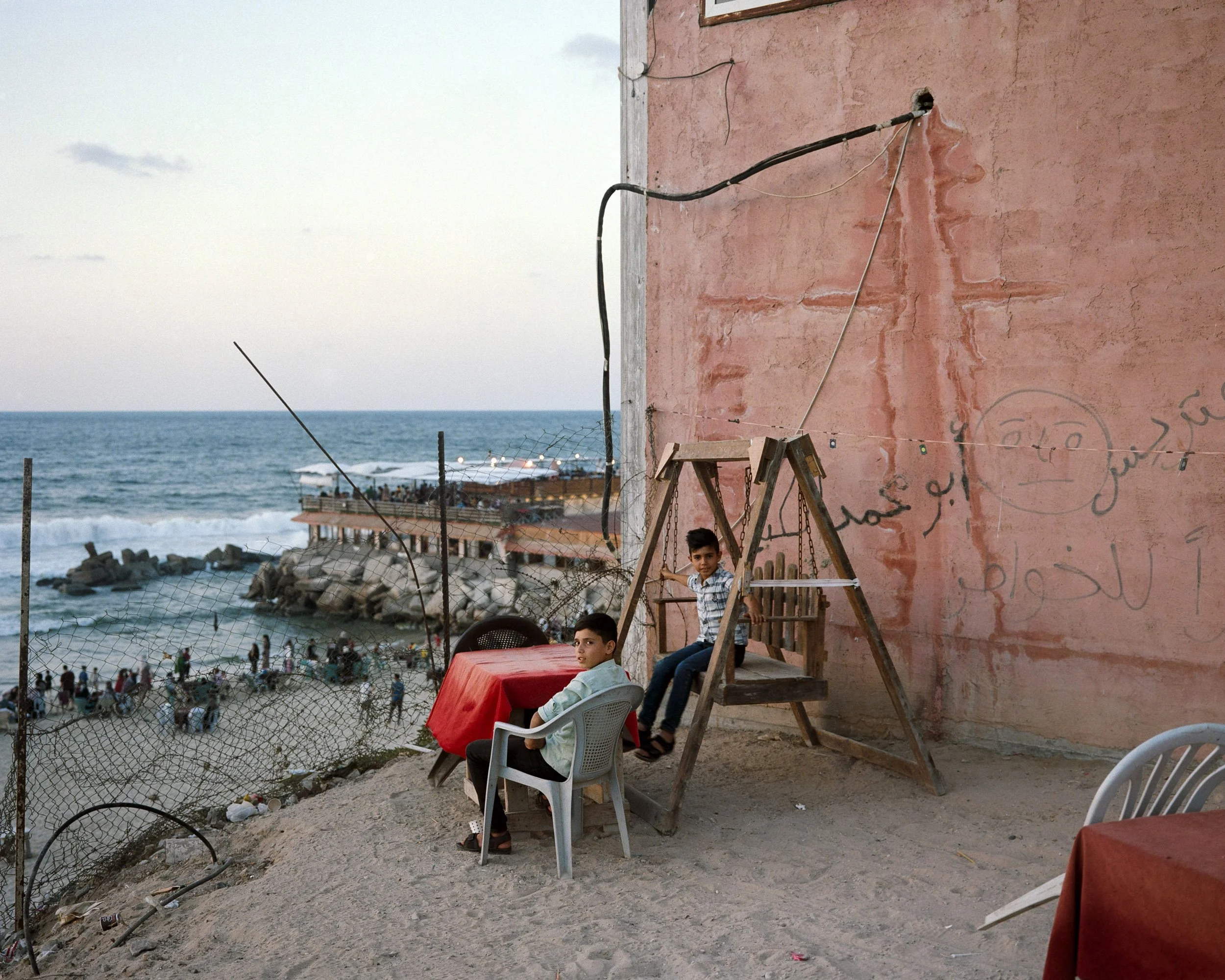 wo children enjoy the view above a beach in Gaza City, October 6, 2022. In the background, Al-Baqa cafe. © Lucien Lung / Riva-Press