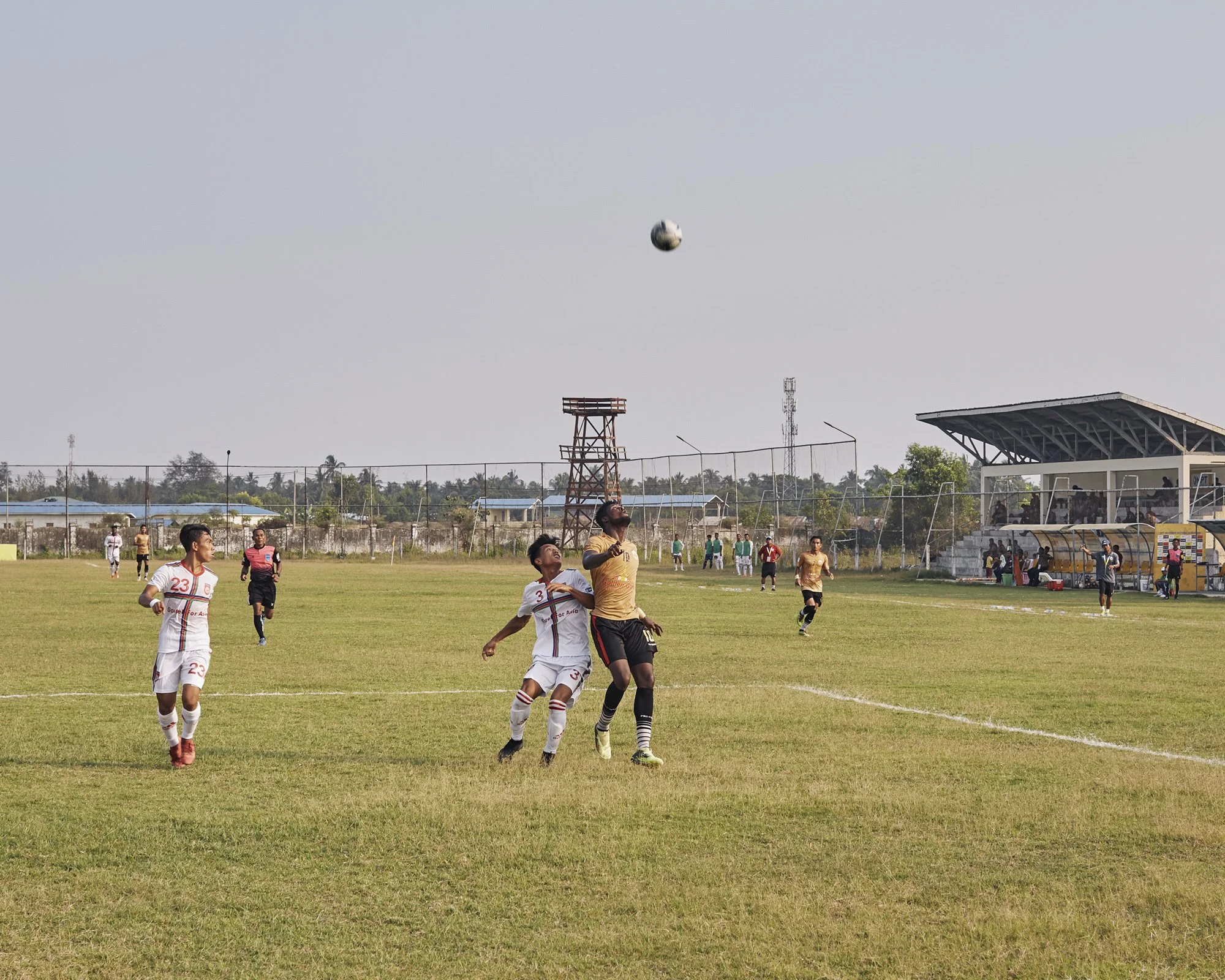 Samuel battles with players from the opposing team during the Rakhine United Football Club vs Chinland game, July 4 2019 Sittwe, Rakhine, Myanmar. © Lucien Lung / Riva