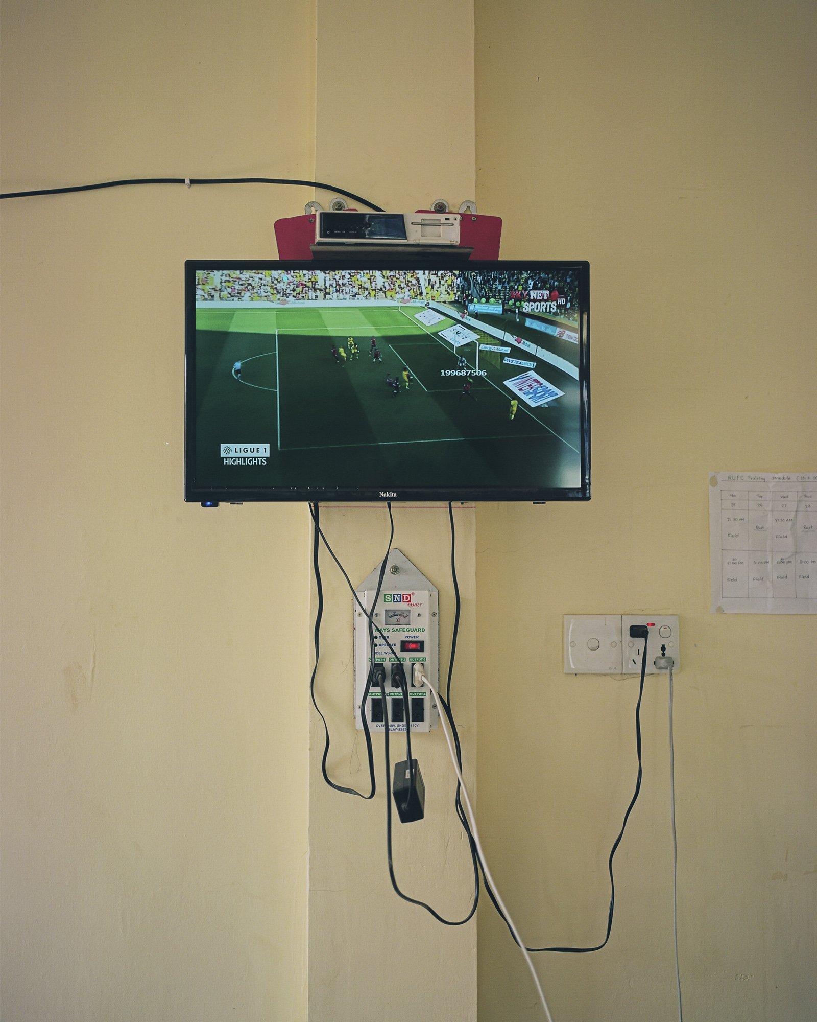 Ligue 1 highlights on the TV in the Rakhine United FC dorms, Sittwe, Rakhine State, Myanmar. April 1st 2019. © Lucien Lung / Riva