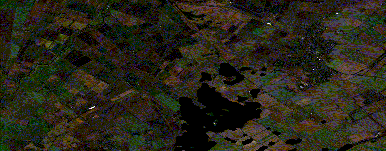 Aerial timelapse view of farmland with green and brown fields.