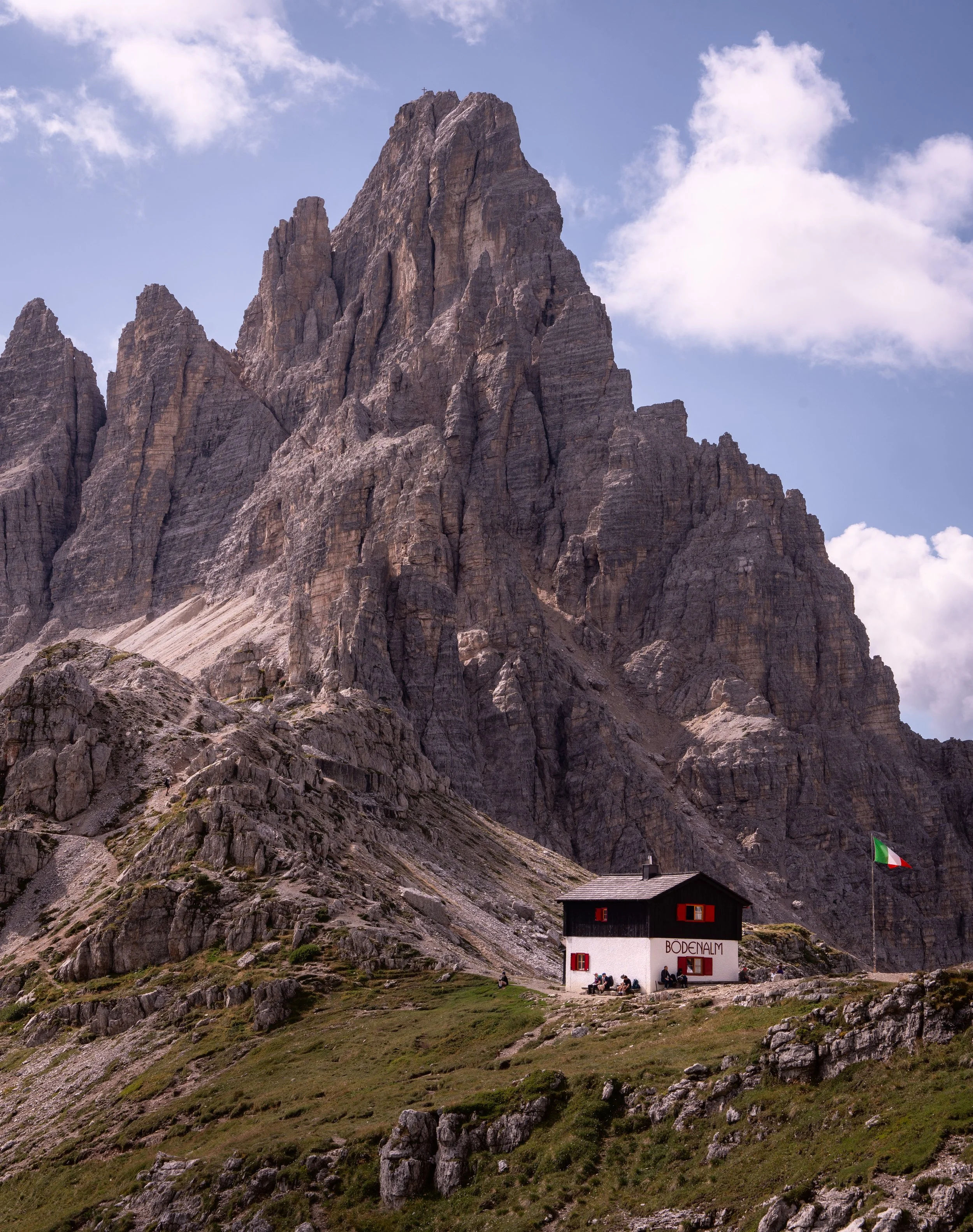 Rifugio Locatelli standing below the Sexten peaks, Dolomites, Italy — a working mountain hut at 2,405 metres, positioned for the view back to Tre Cime and reachable only on foot.
