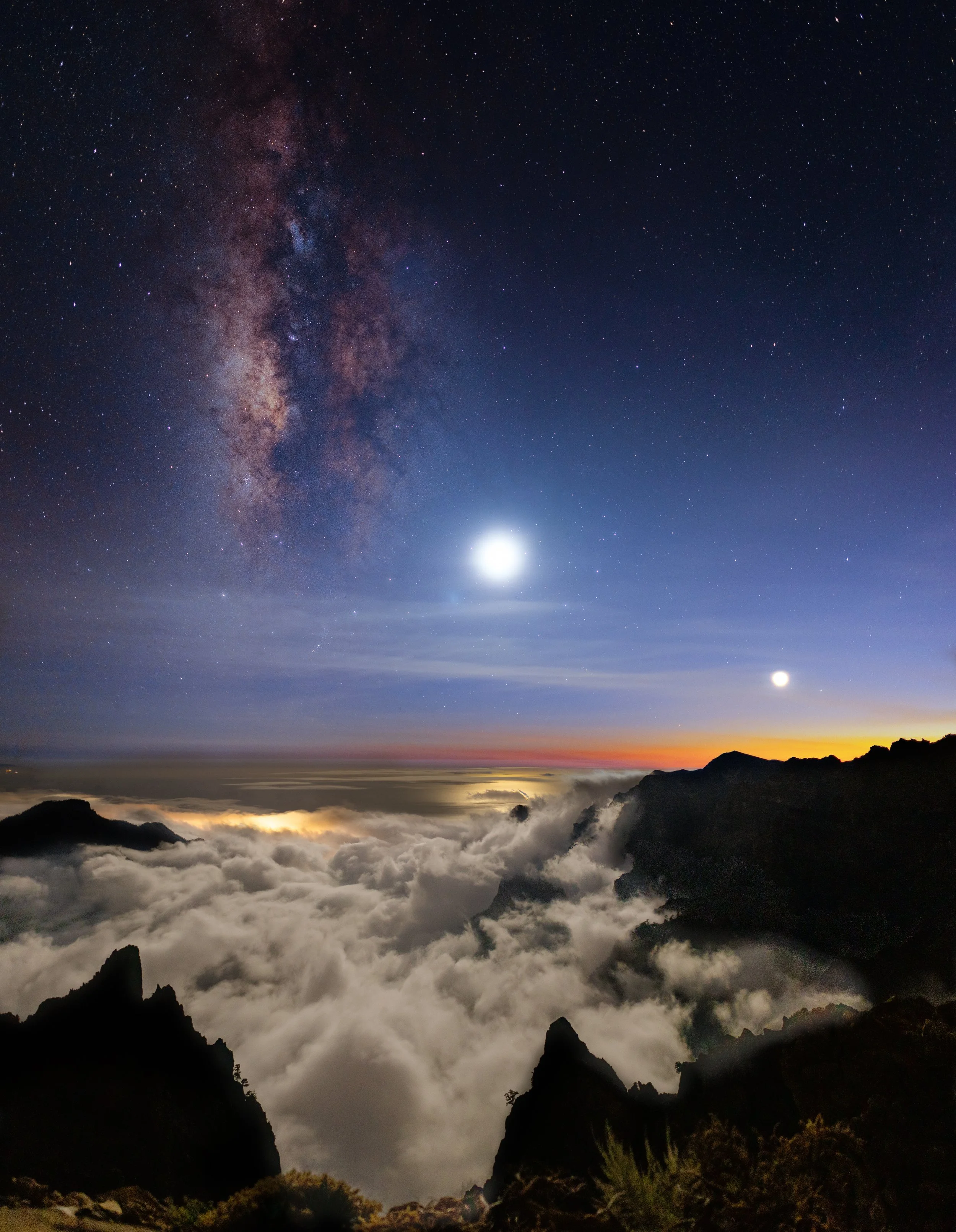 The Milky Way over the cloud sea filling the Caldera de Taburiente, seen from near Roque de los Muchachos, La Palma, with the moon and Venus low in the twilight — the trade-wind inversion holds the cloud below 1,800 metres, leaving the summit clear a