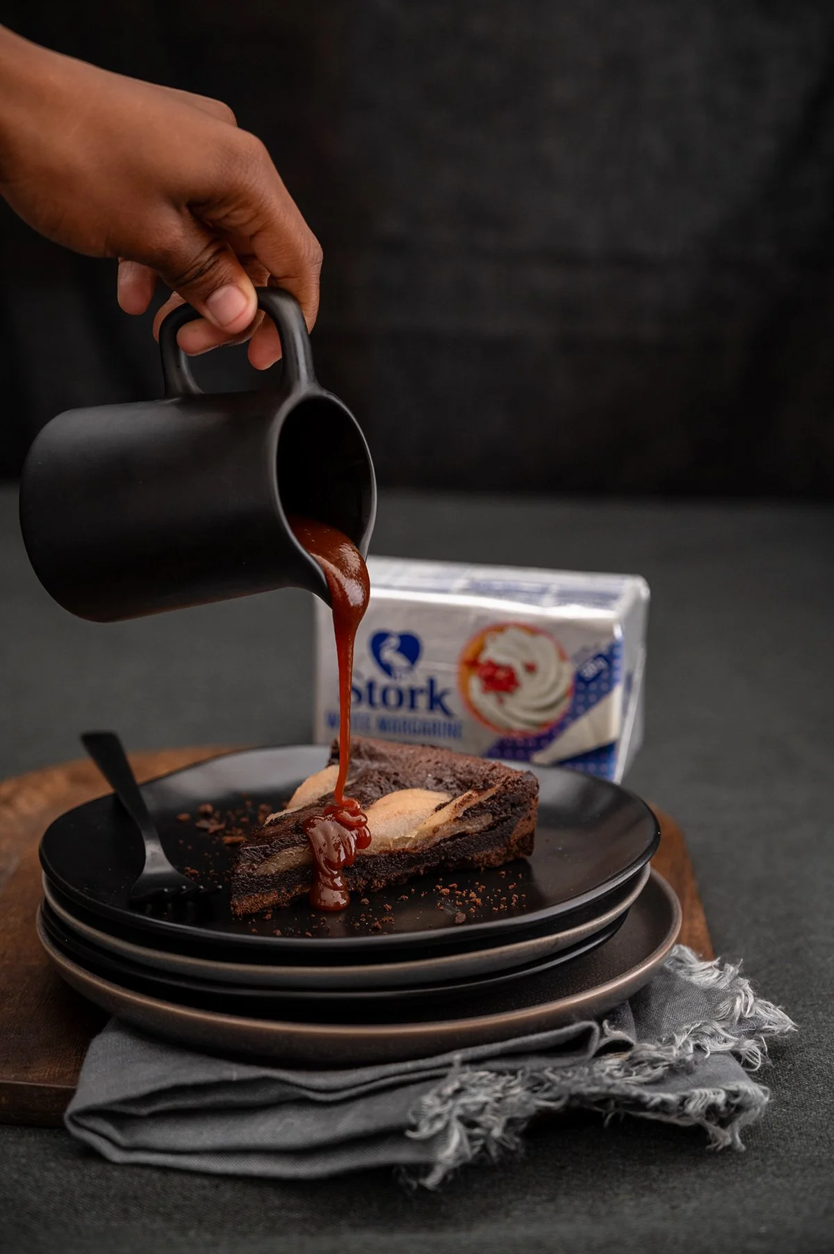 stork-chocolate-pear-tart-caramel-pour-hand.jpg