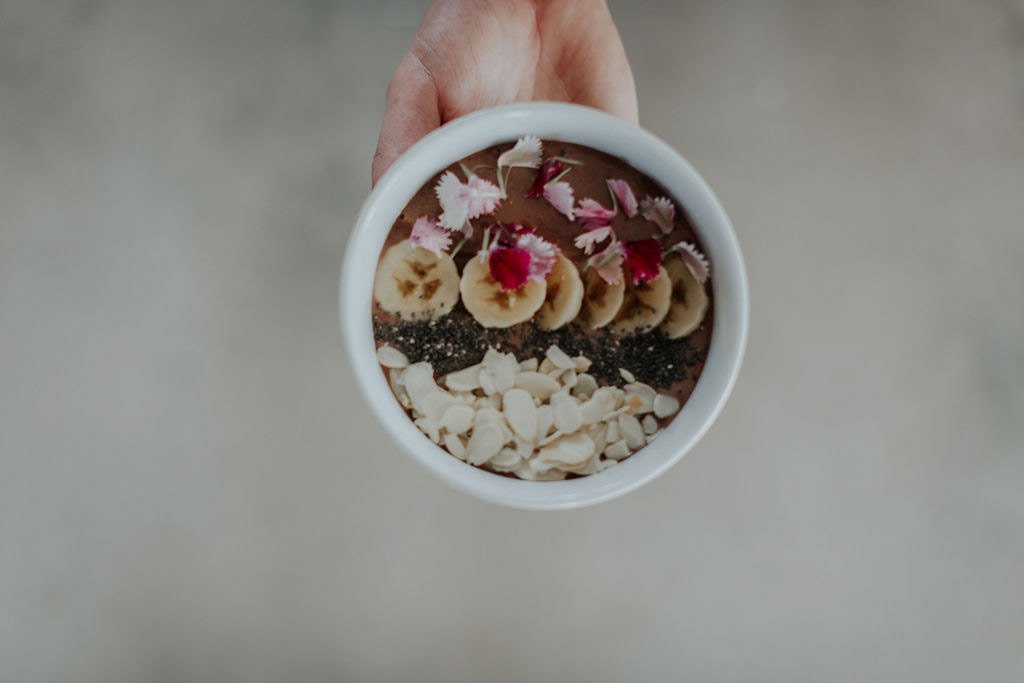smoothie-bowl-with-edible-flowers-in-hand.jpg