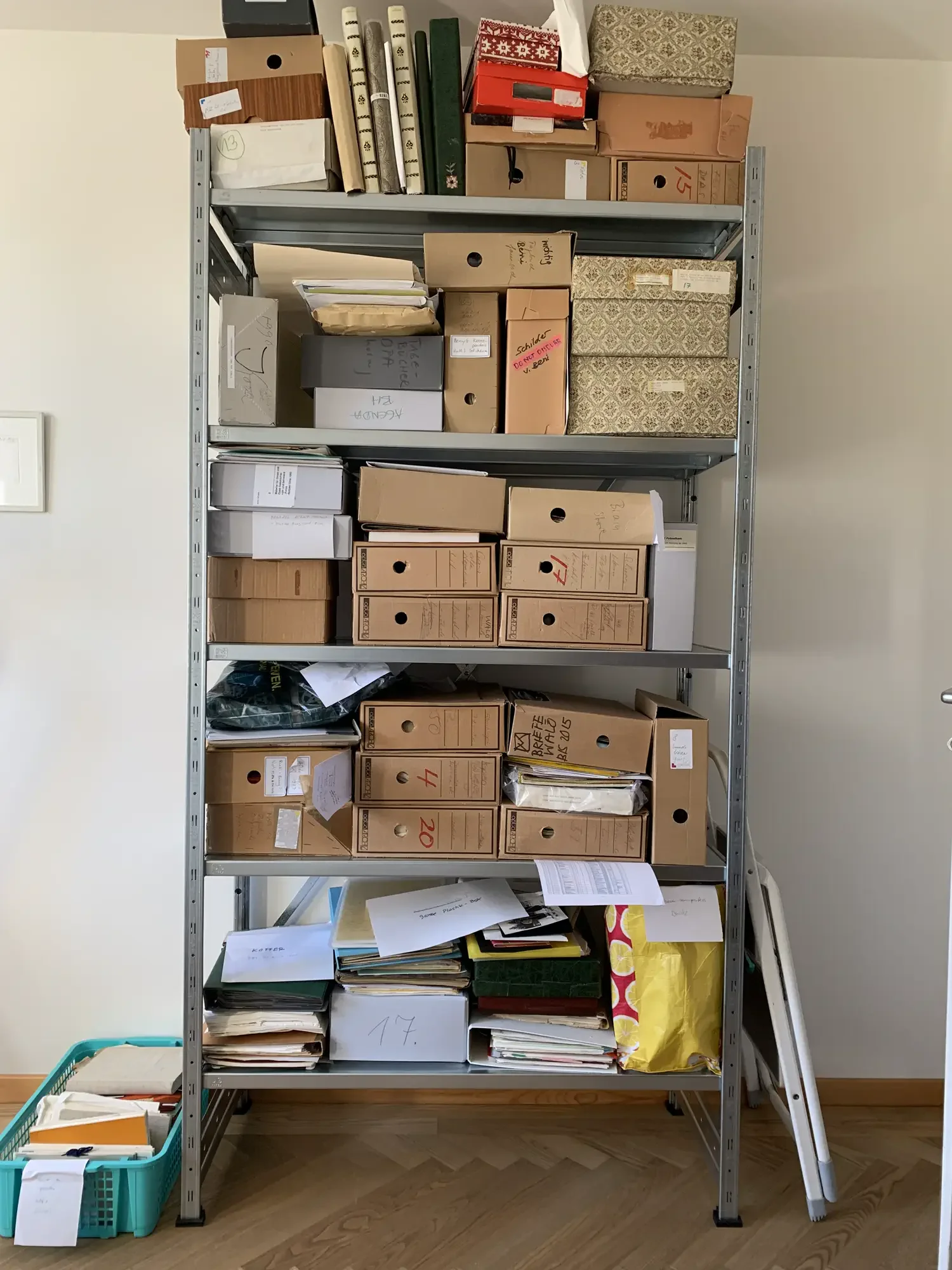 A disorganized archive shelf with loose folders and boxes, before being properly organized.