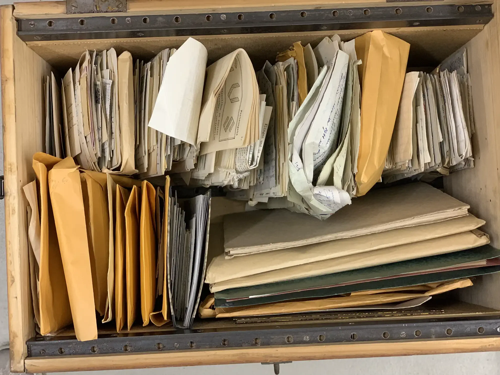 Unsorted documents in an open storage bin, awaiting proper archiving.