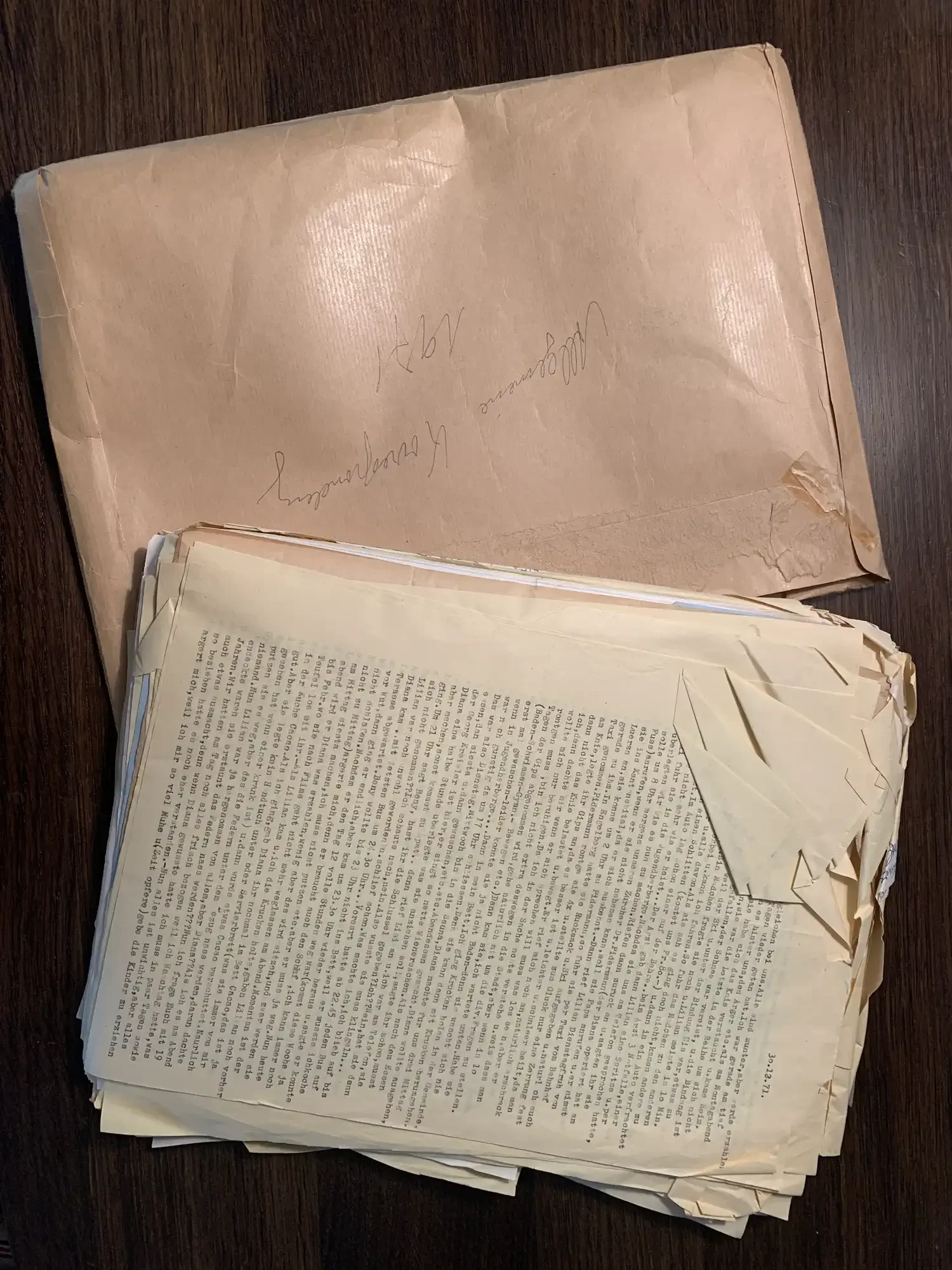 Archival documents with creased corners before being gently smoothed out.