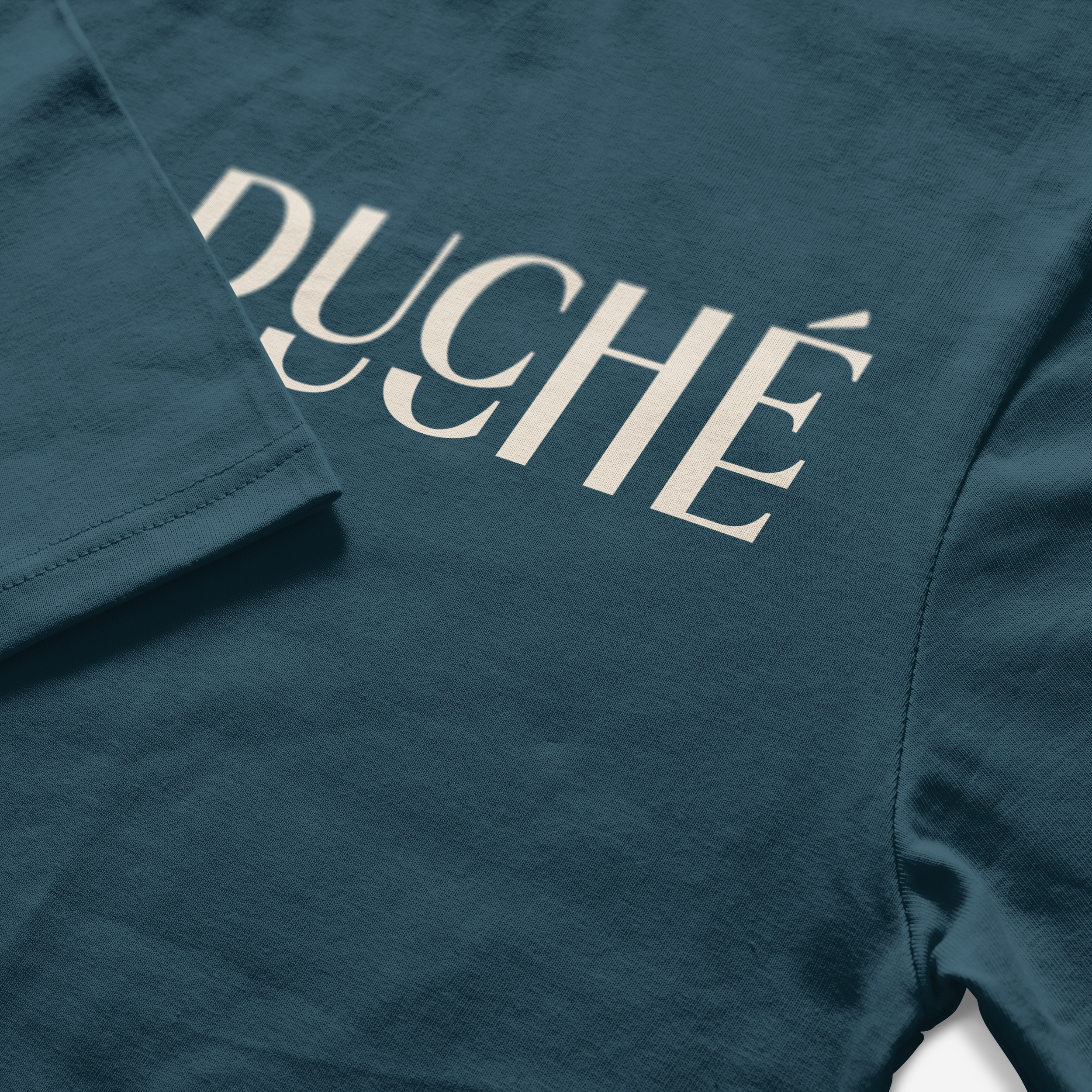 Gros plan d'un t-shirt bleu foncé avec le mot 'duché' en lettres blanches.