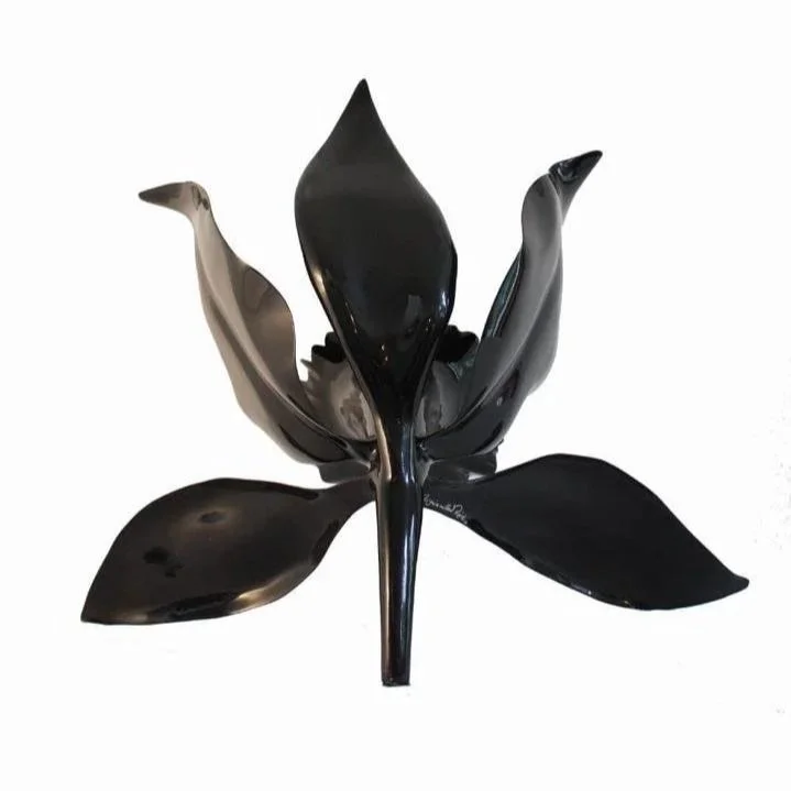 Black metal sculpture of a flower with large petals.