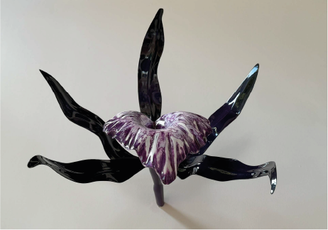 A glass sculpture of a flower with purple and black petals.