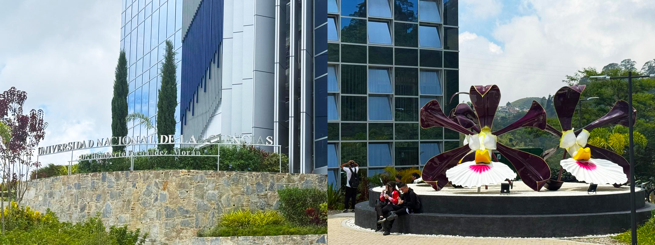 Exterior of Universidad Nacional de Ciencias building with large flower sculpture in foreground and students sitting nearby.