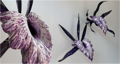 Decorative purple and silver artificial orchids with black leaves and stems.