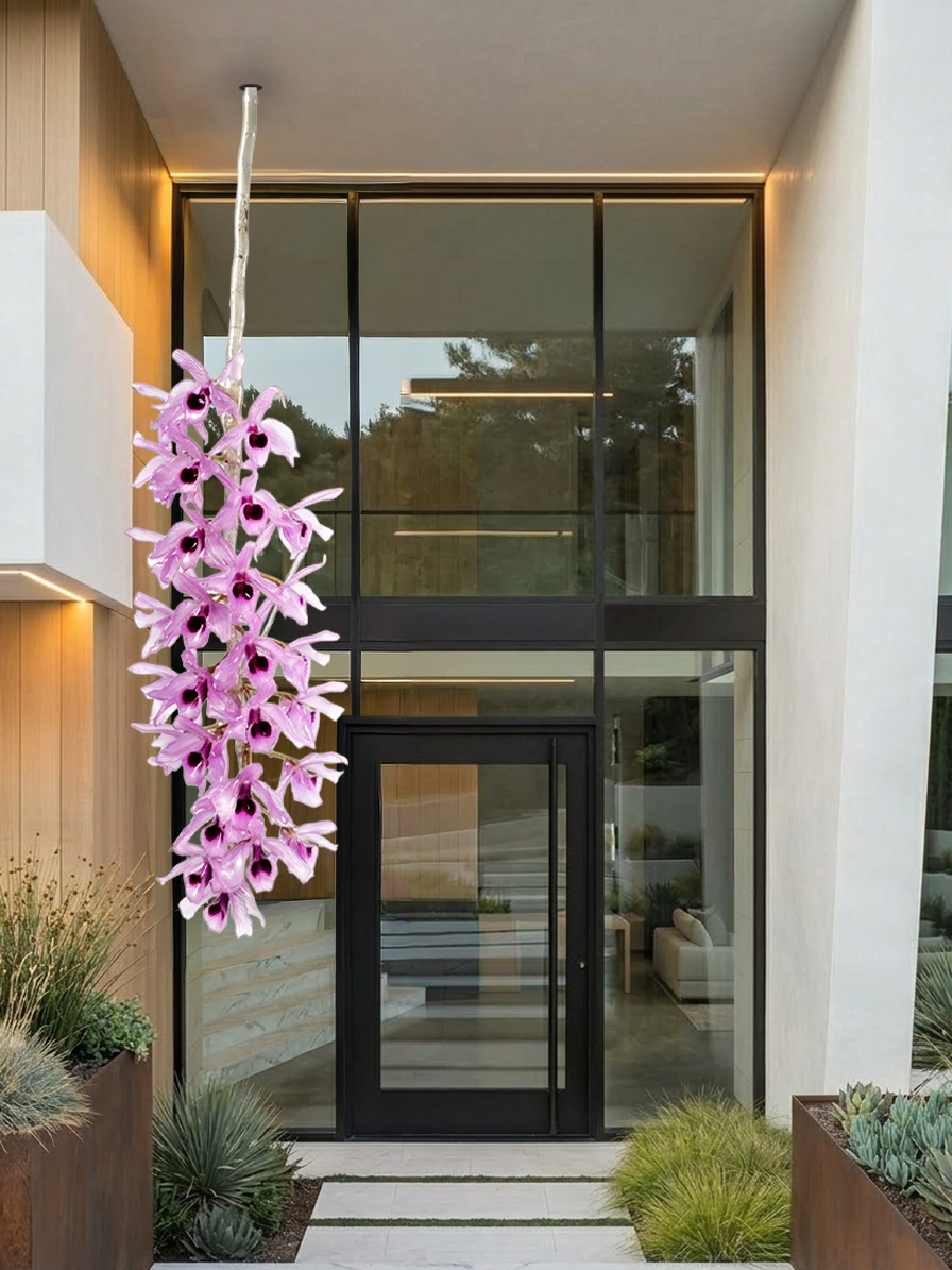 Modern building exterior with large glass windows, black door, and decorative plants including purple orchid.