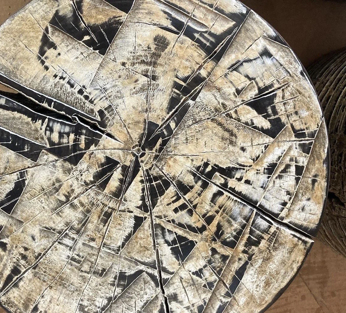 A close-up view of a broken wooden table top showing numerous cracks and splits in the wood.