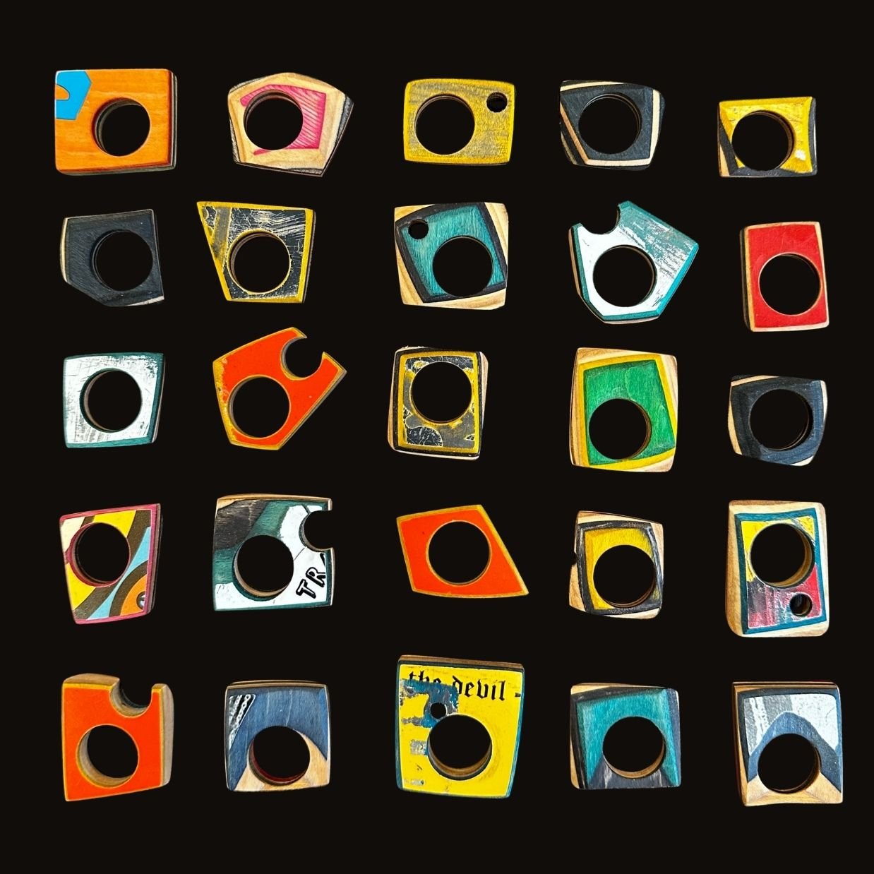 Colorful toy building blocks with various shapes and drawings, laid out on a black background.