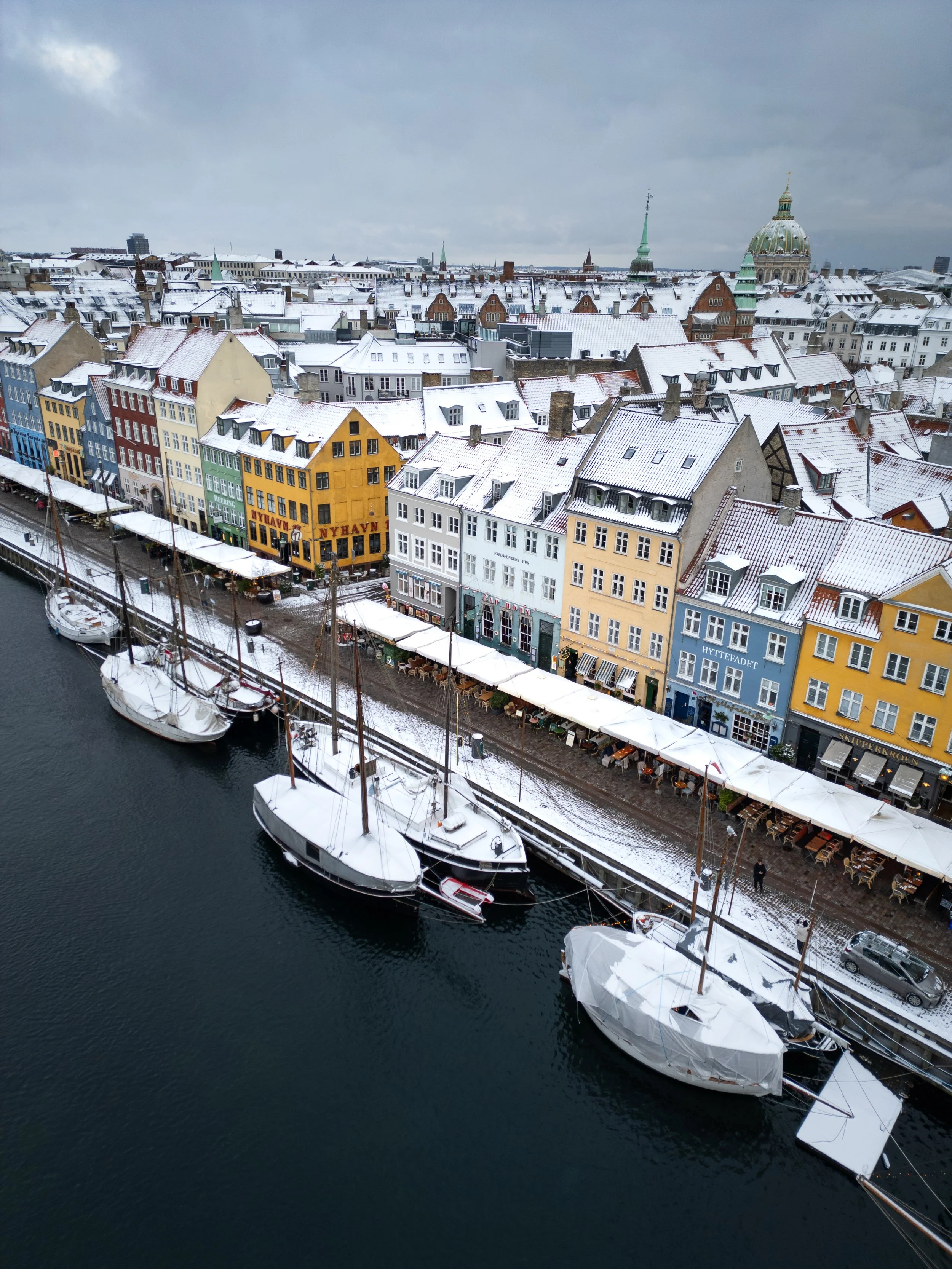 Dronefoto af sneklædt Nyhavn, København.
