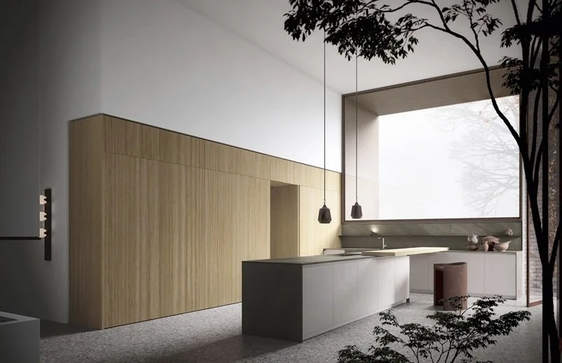 Interno di una cucina moderna con grandi finestre, mobili bianchi e pannelli di legno chiaro.