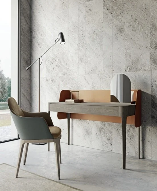 Interno elegante con scrivania in legno e specchio, sedia moderna e lampada da parete, grande finestra con vista su un paesaggio naturale.