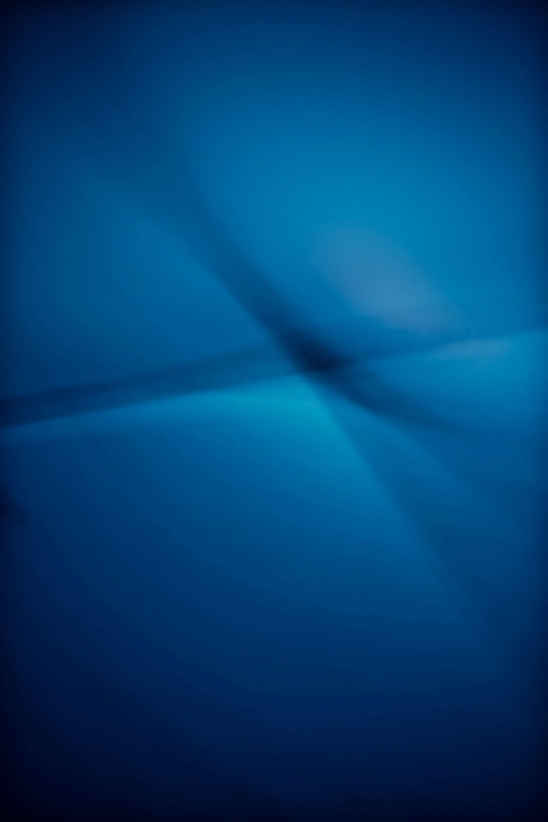 Blauer, abstrakter Hintergrund mit weichen Licht- und Schattenverläufen.