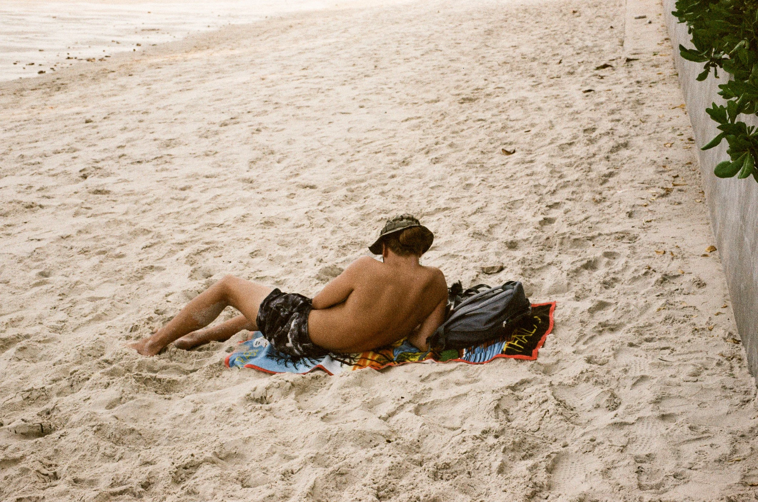 candid photography of a men lying on the sand at Hua Hin, Thailand