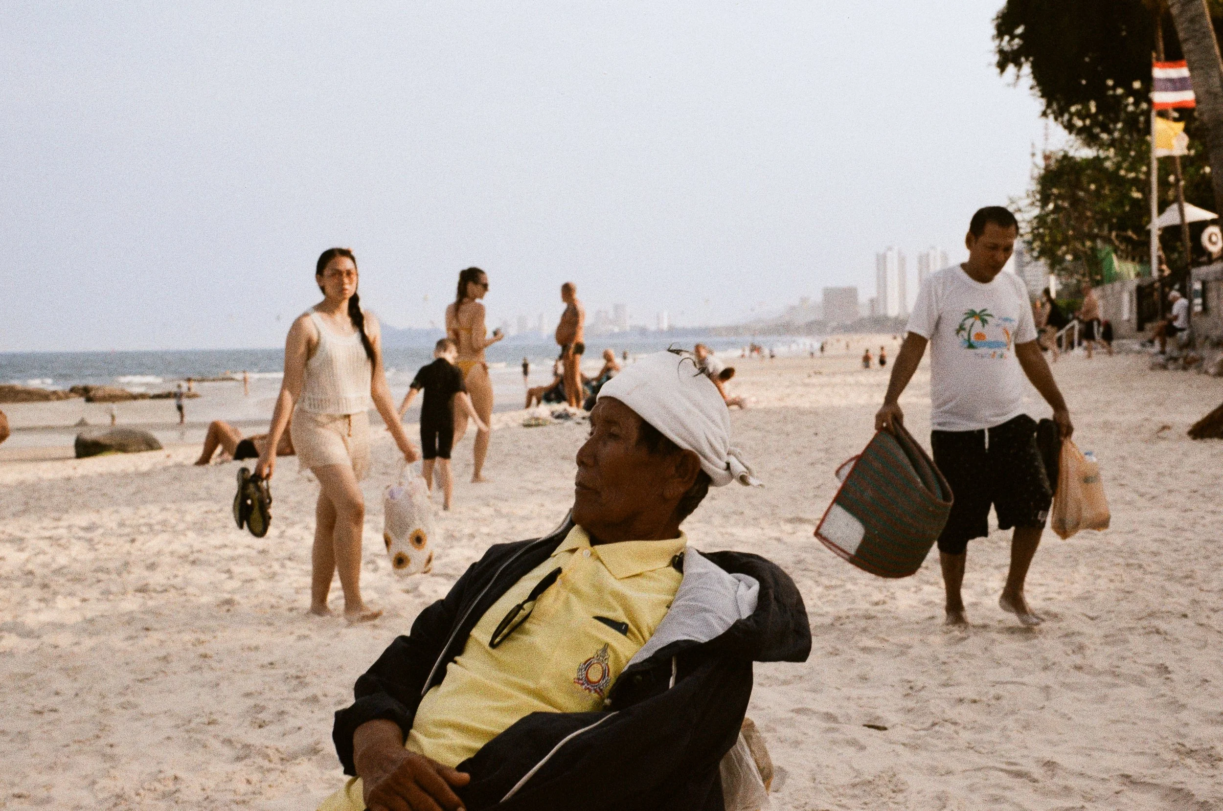 A candid portrait of local people and visitors enjoying a sunny day at Hua Hin beach.